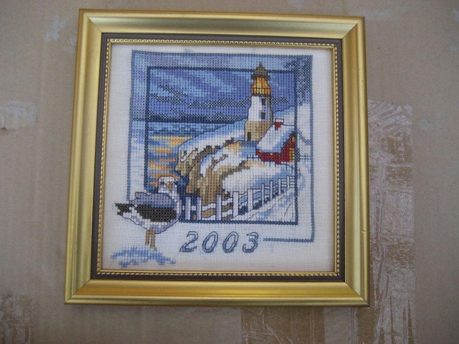 Tavla handsydd med motiv på hus & fyr i vinterlandskap - Årstavla 2003