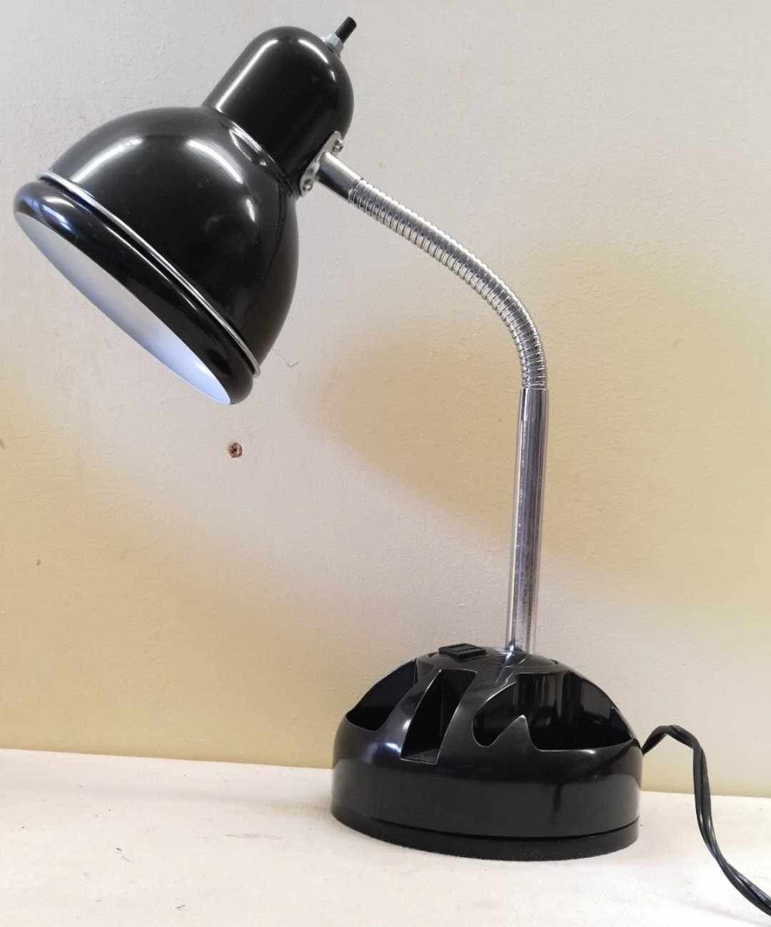 Svart skrivbordslampa med böjbar hals och förvaringsutrymme på foten