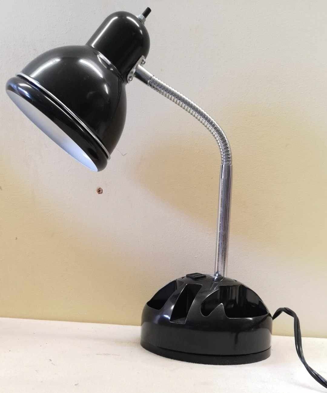 Svart skrivbordslampa med böjbar hals och förvaringsutrymme på foten