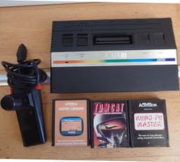 Atari 2600 med kontroller och spel. Kung Fu Master, Chopper Command och Tomcat