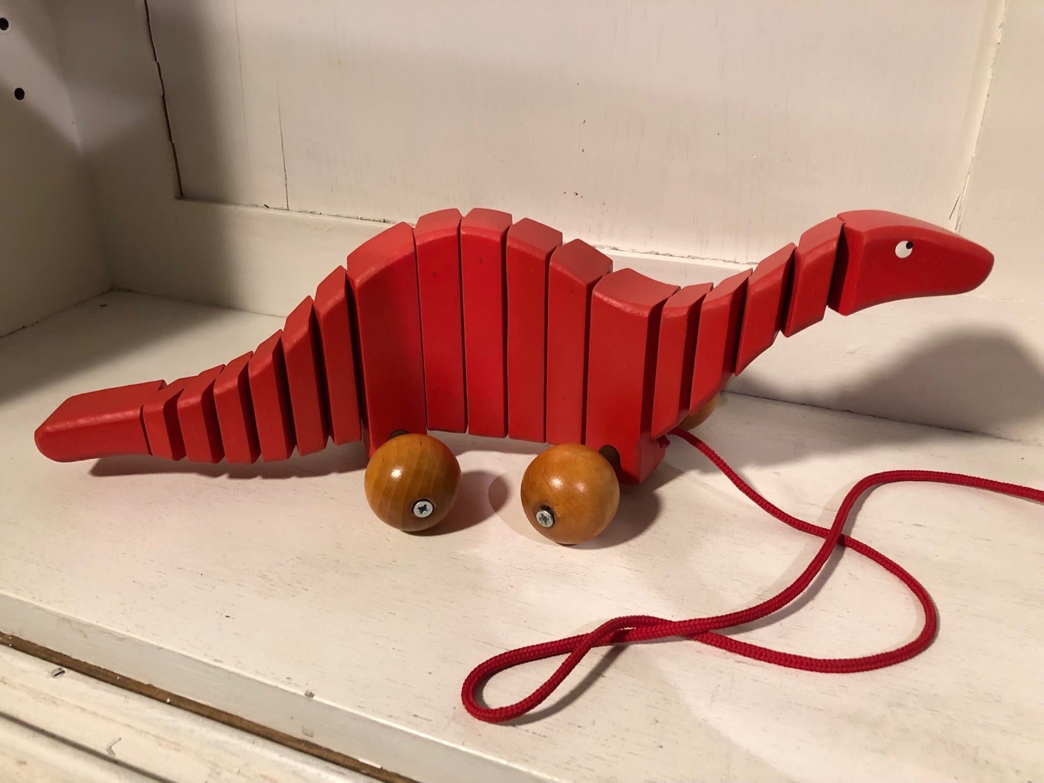 Trä dragleksak röd dinosaurie med snöre