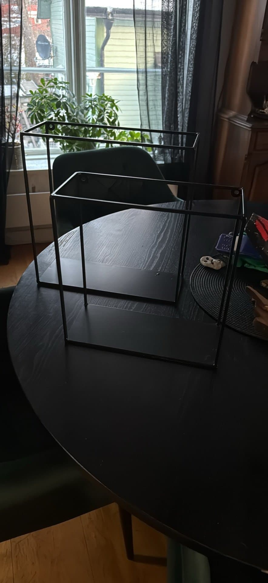 Två svarta hyllor i metall