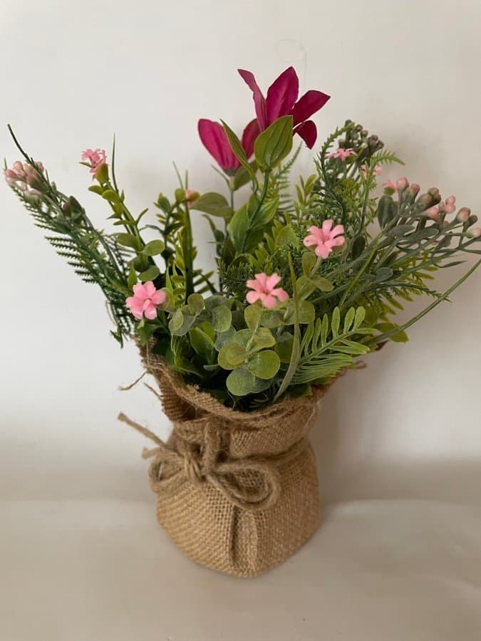 Konstgjorda blommor i kruka av juteväv