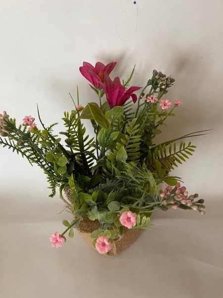 Konstgjorda blommor i kruka av juteväv