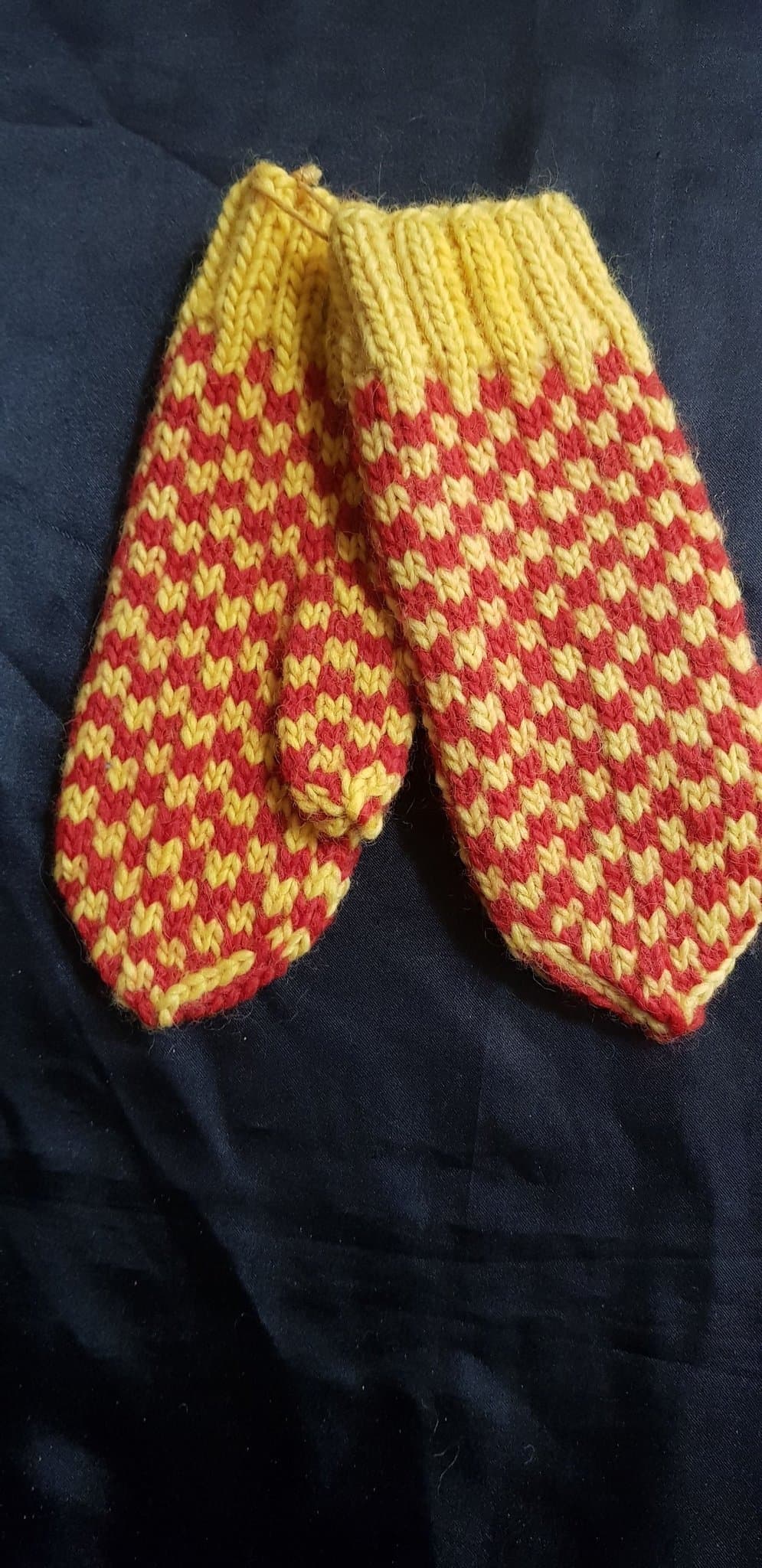 Röda, gula vantar i ullgarn