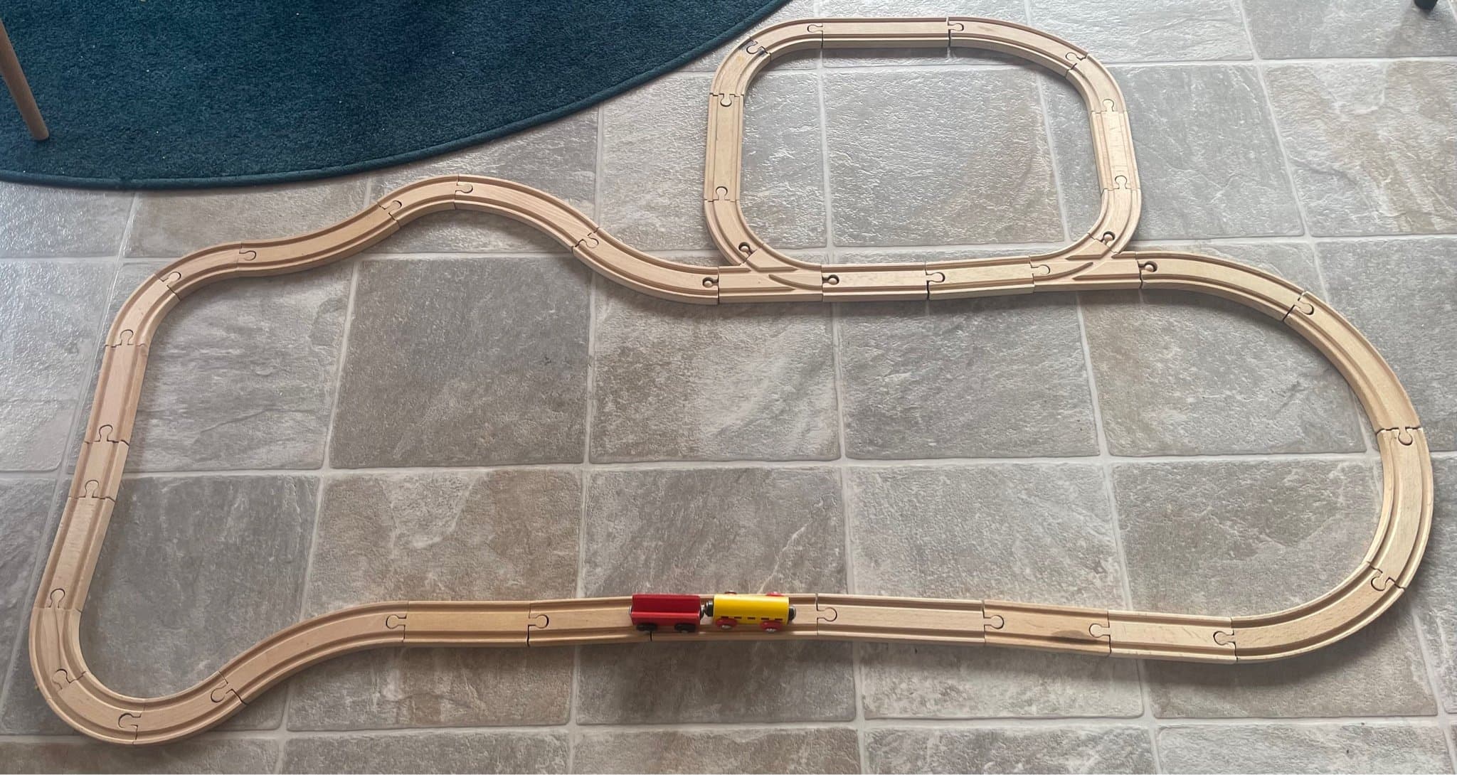 Tågbana i trä med vagnar tror det är BRIO