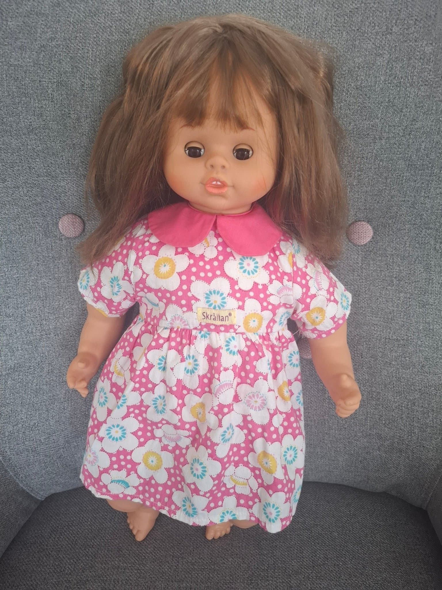 Skrållan docka med talfunktion och blommig klänning