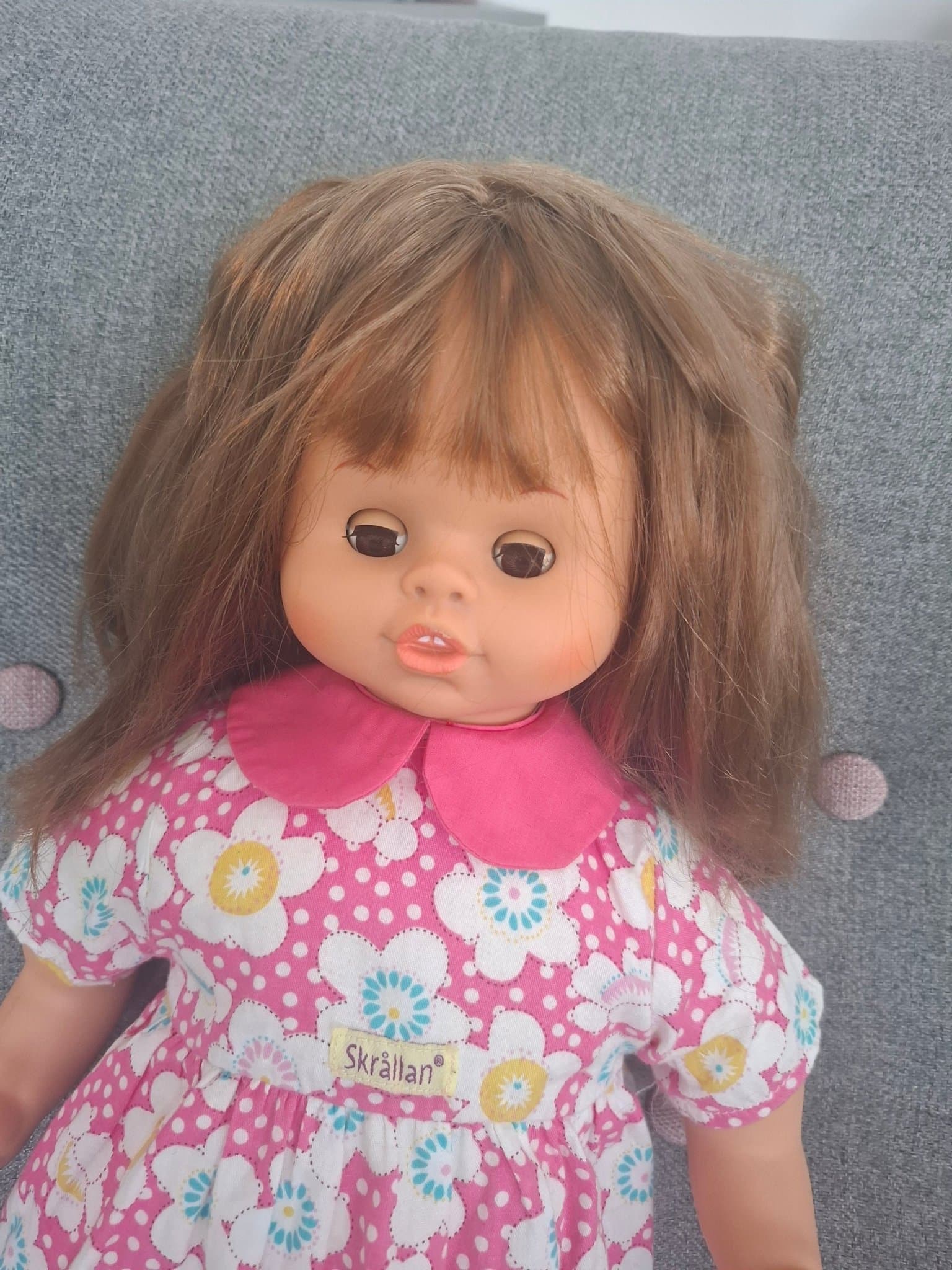 Skrållan docka med talfunktion och blommig klänning