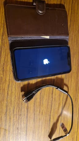 iPhone XR med brunt fodral och sladd