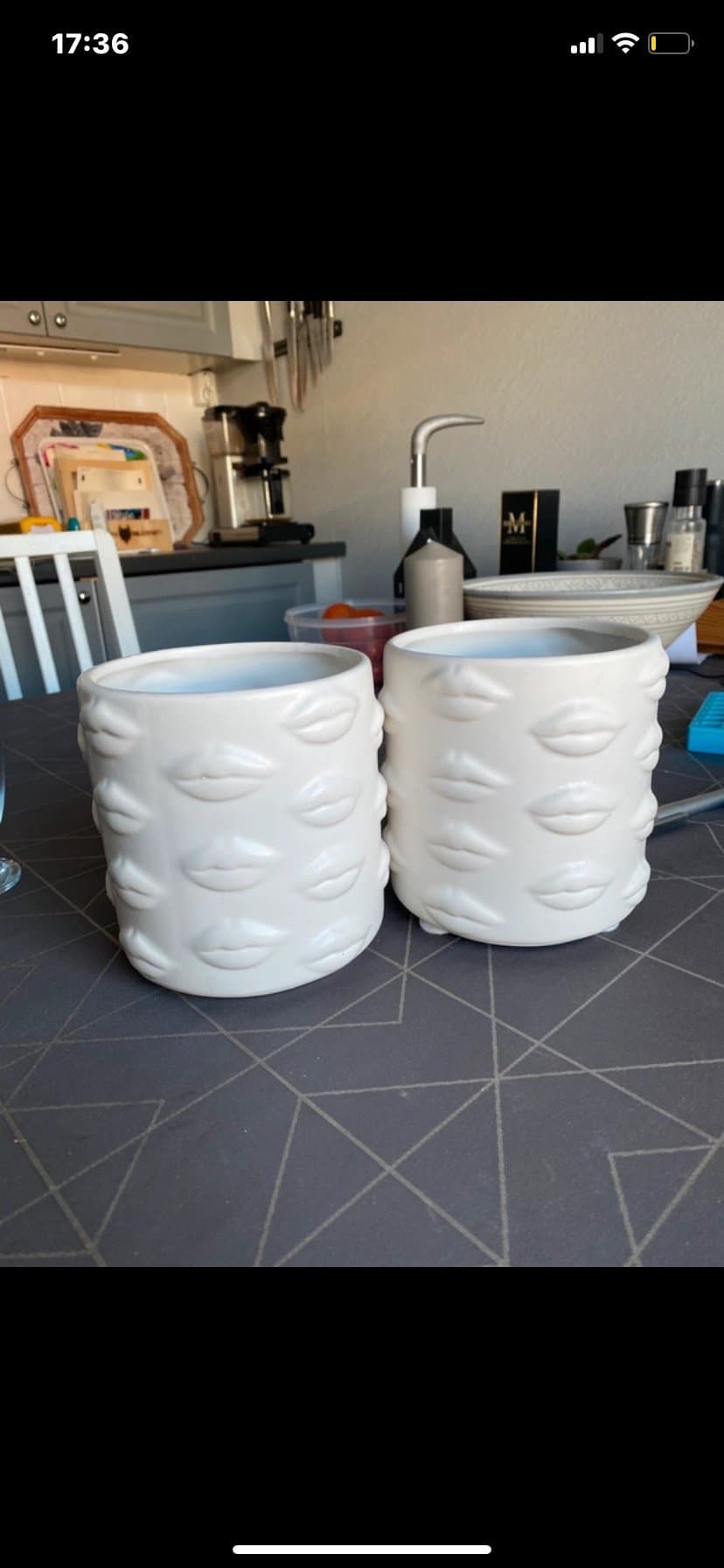 Två vita krukor med läppdesign