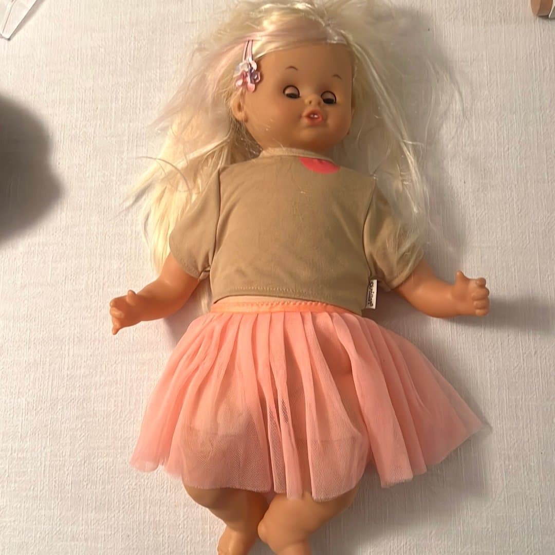 Skrållan docka med blont hår med kjol och tröja