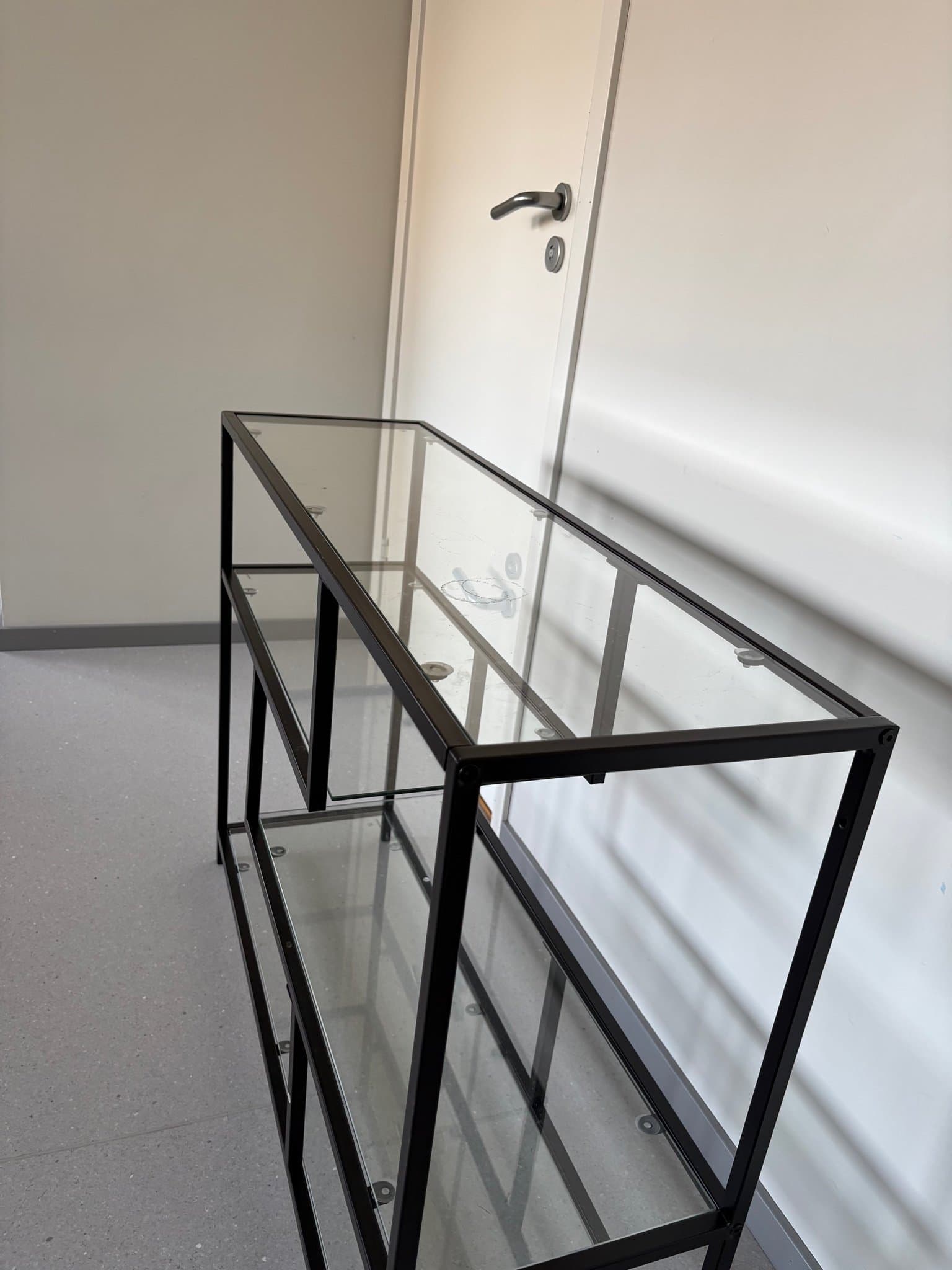 Hylla i svart metall och glas