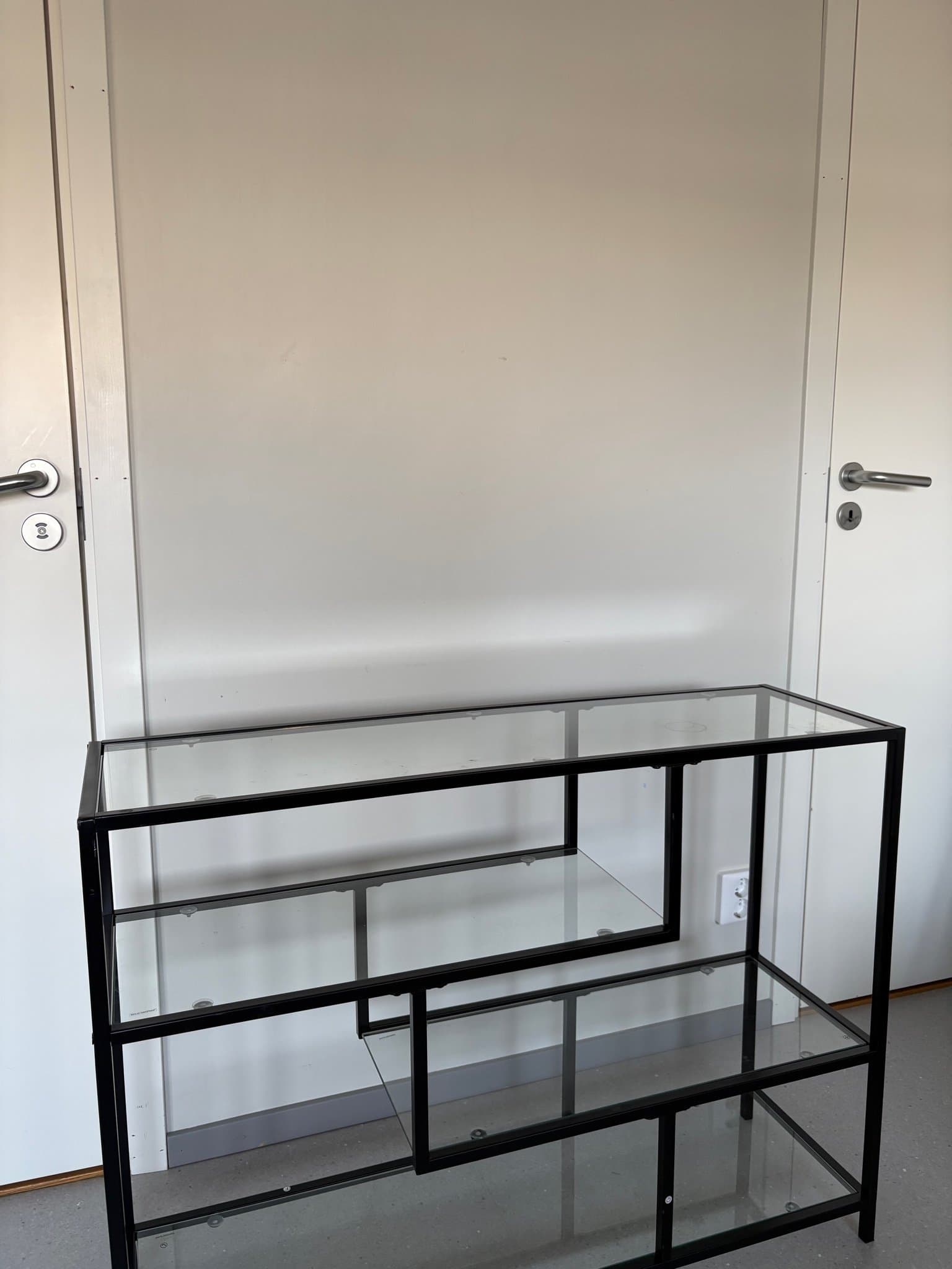 Hylla i svart metall och glas