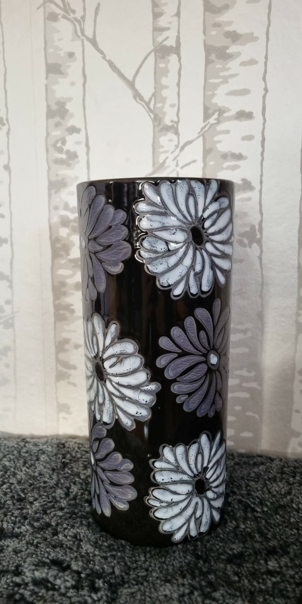 Svart vas med vita och grå blommor