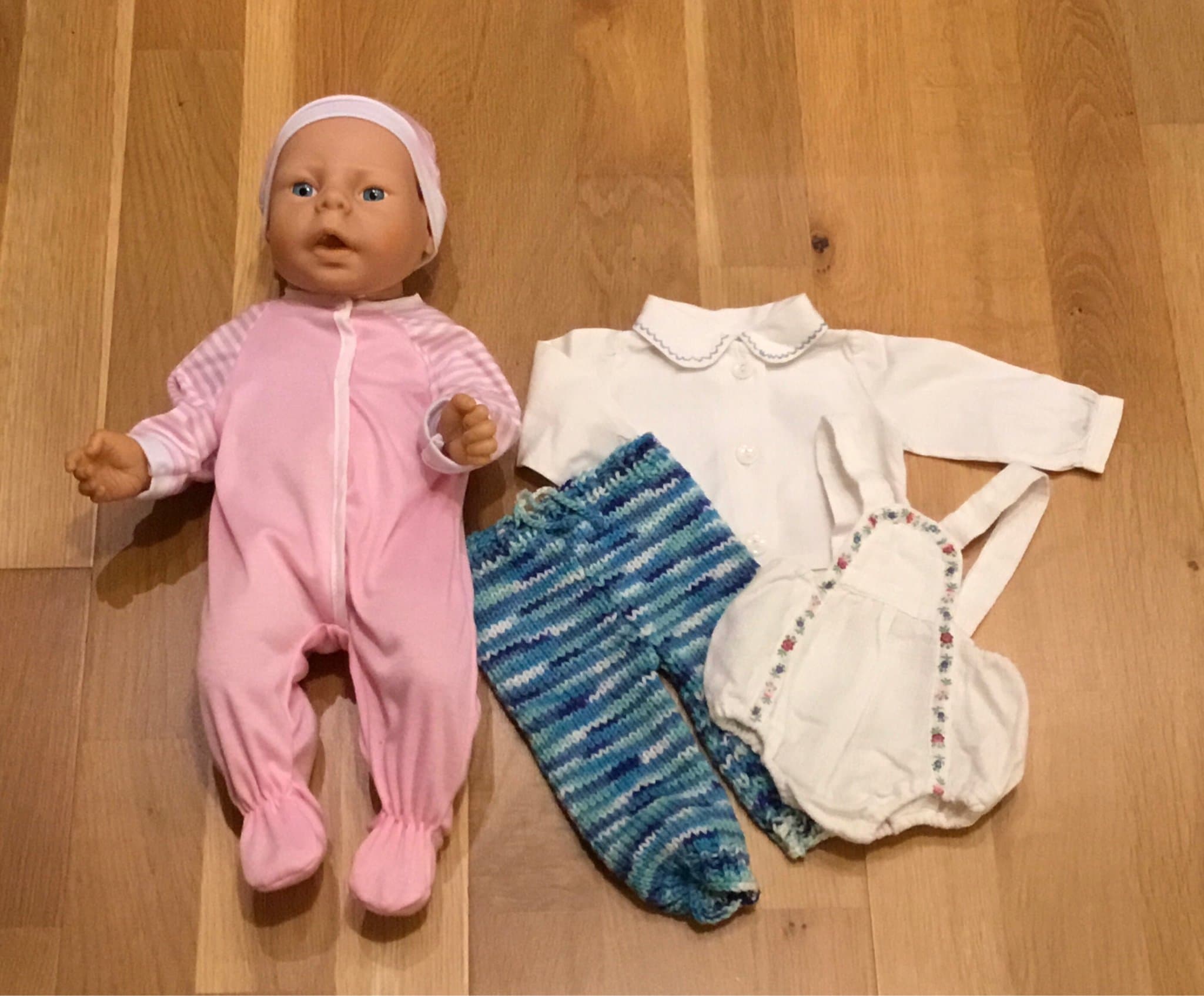 Babydocka nyfödd i vinyl med litet klädpaket, fint använt skick.