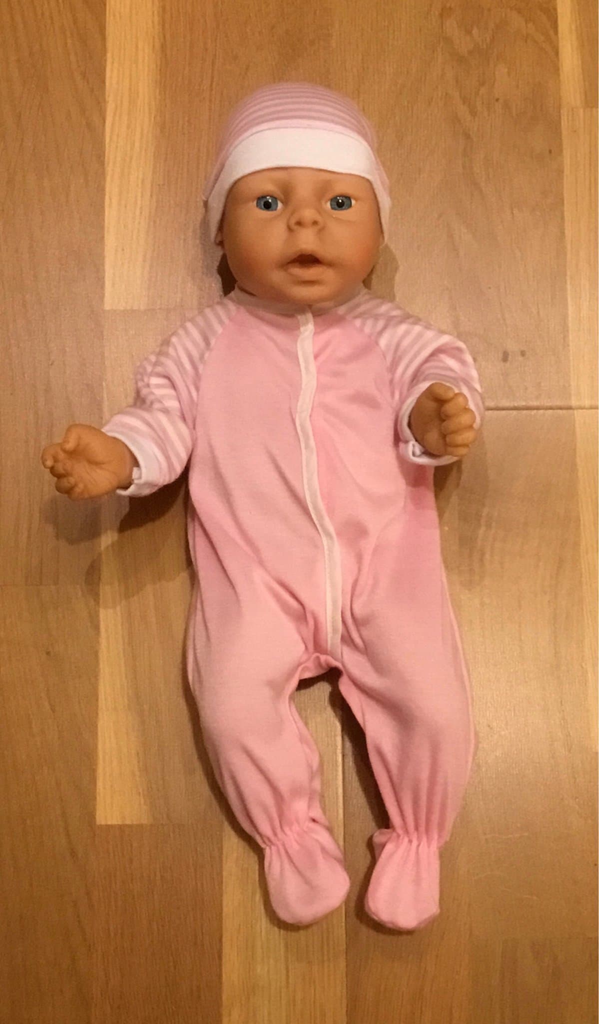 Babydocka nyfödd i vinyl med litet klädpaket, fint använt skick.