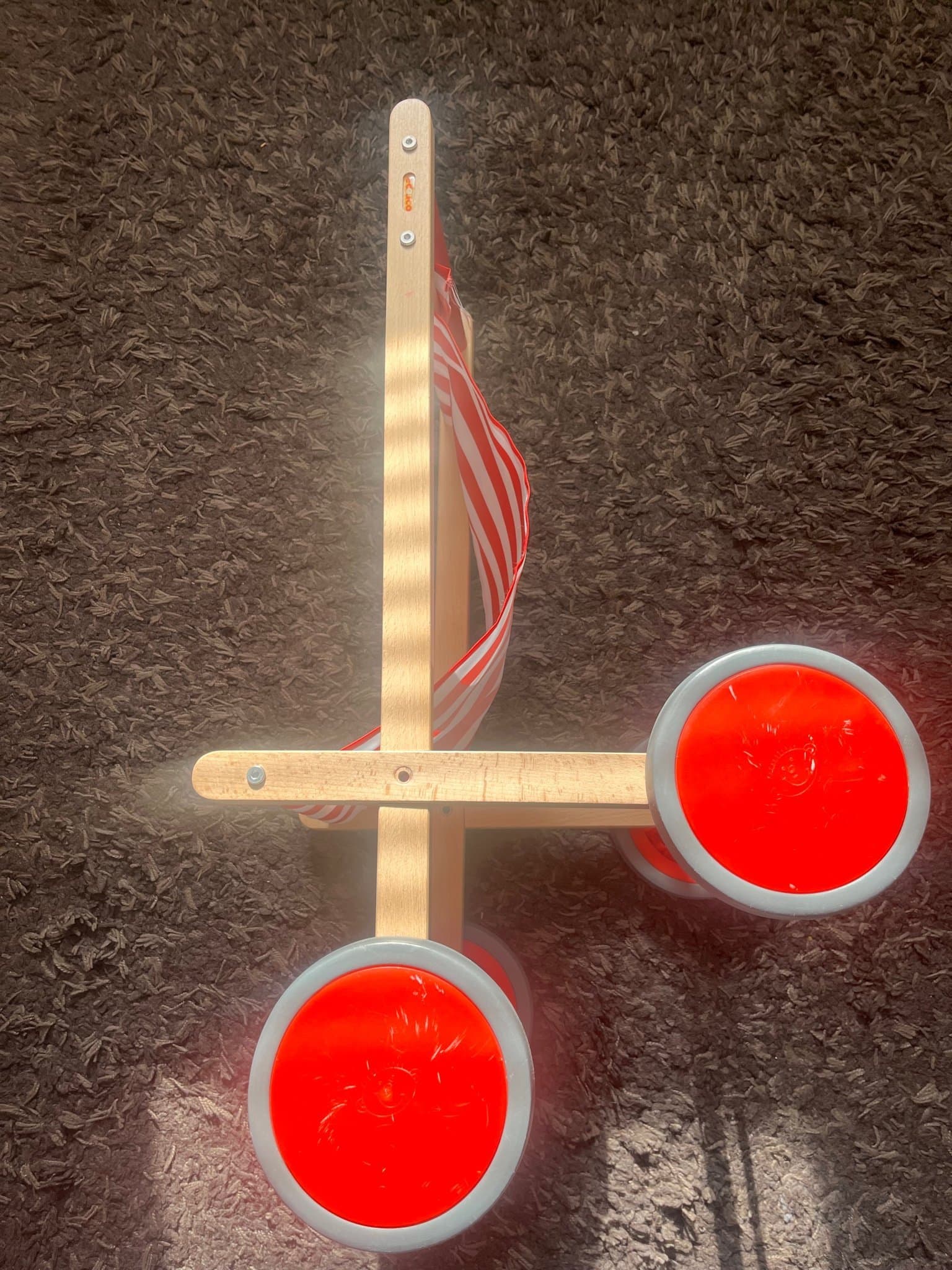 Dockvagn i trä med röd- och vitrandigt tyg från Egmont Toys