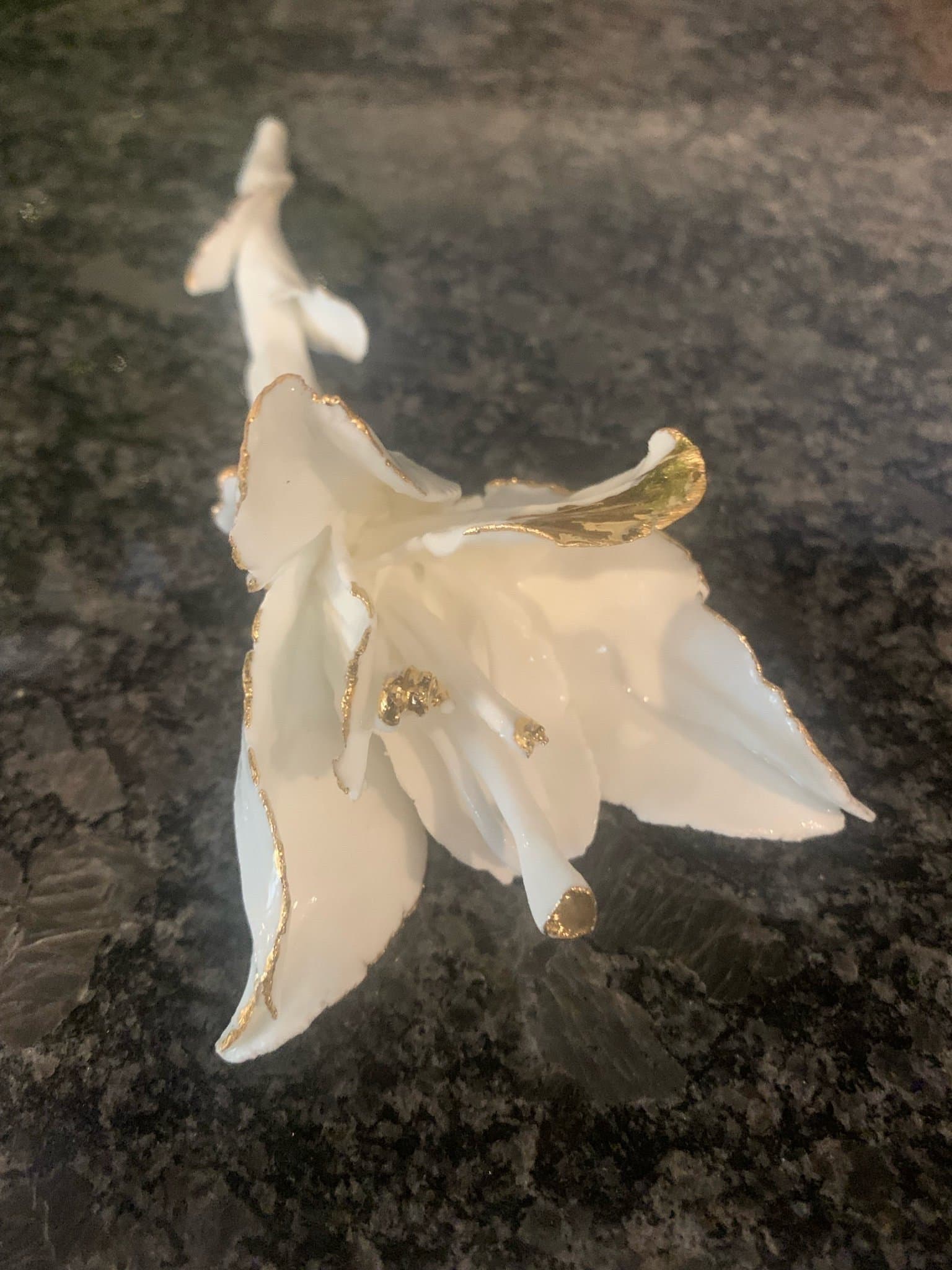 Dekorativ vit porslinsblomma med gulddetaljer