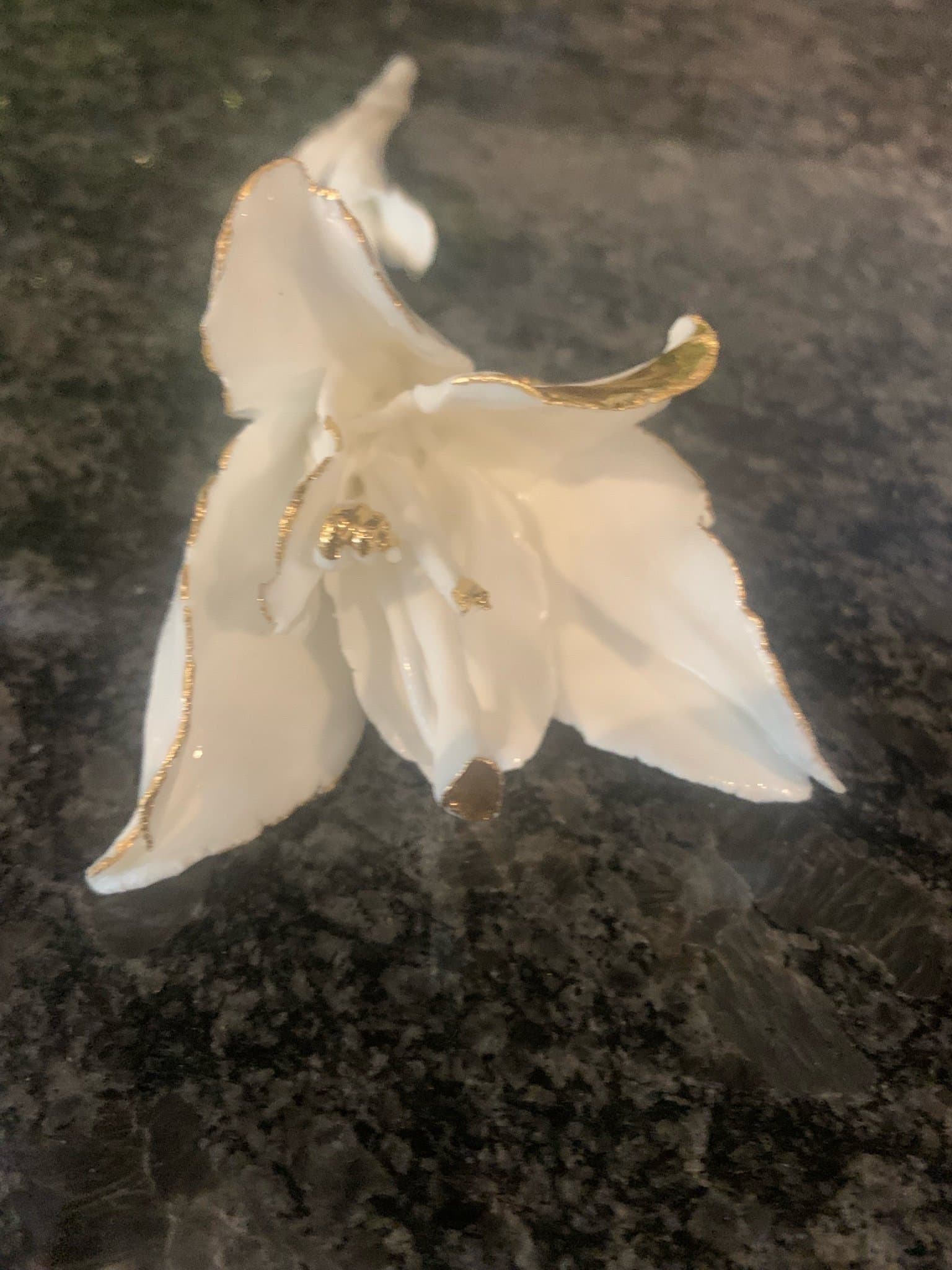 Dekorativ vit porslinsblomma med gulddetaljer