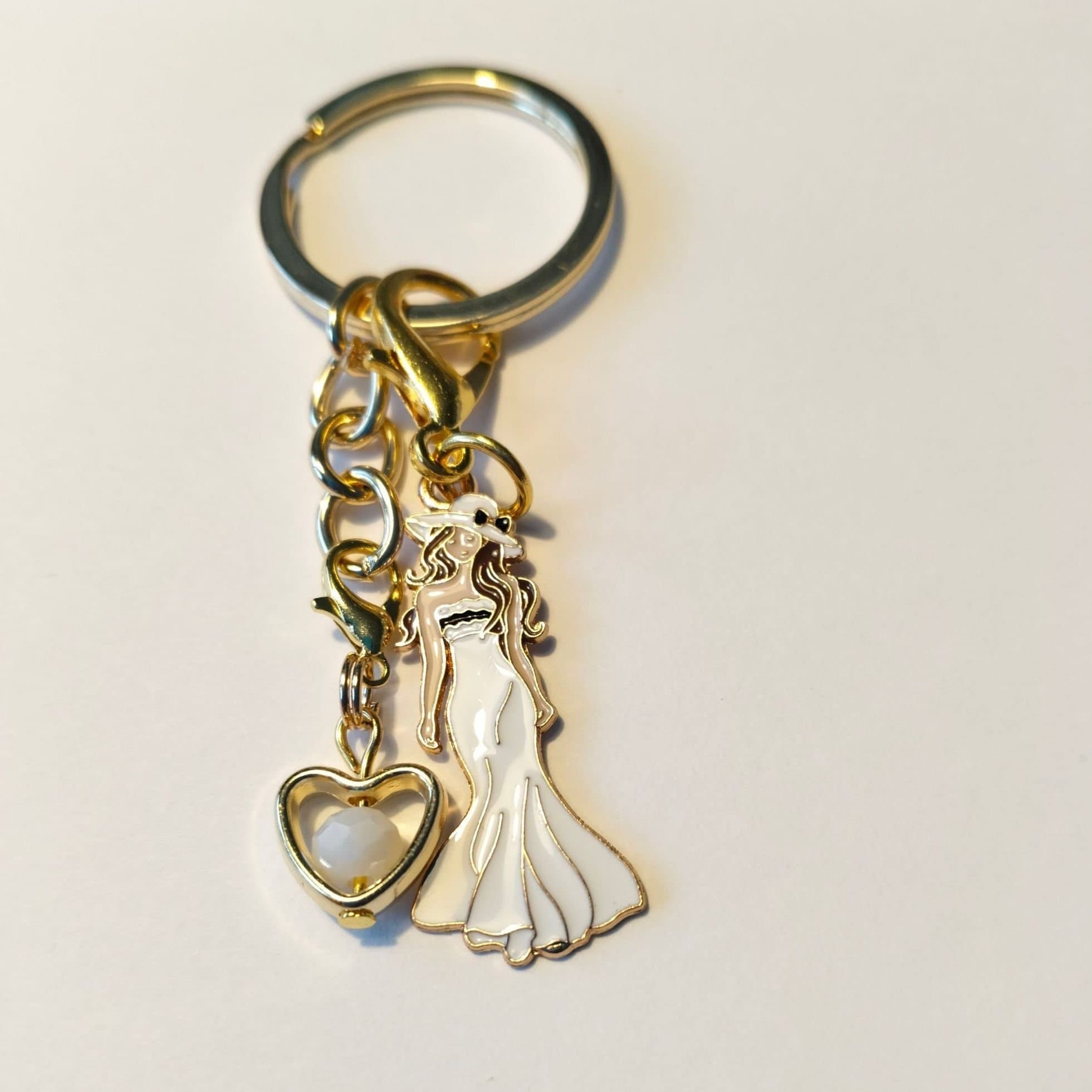 Fin Nyckelring med kvinna i Vit klänning och guld hjärta med Vit pärla inuti