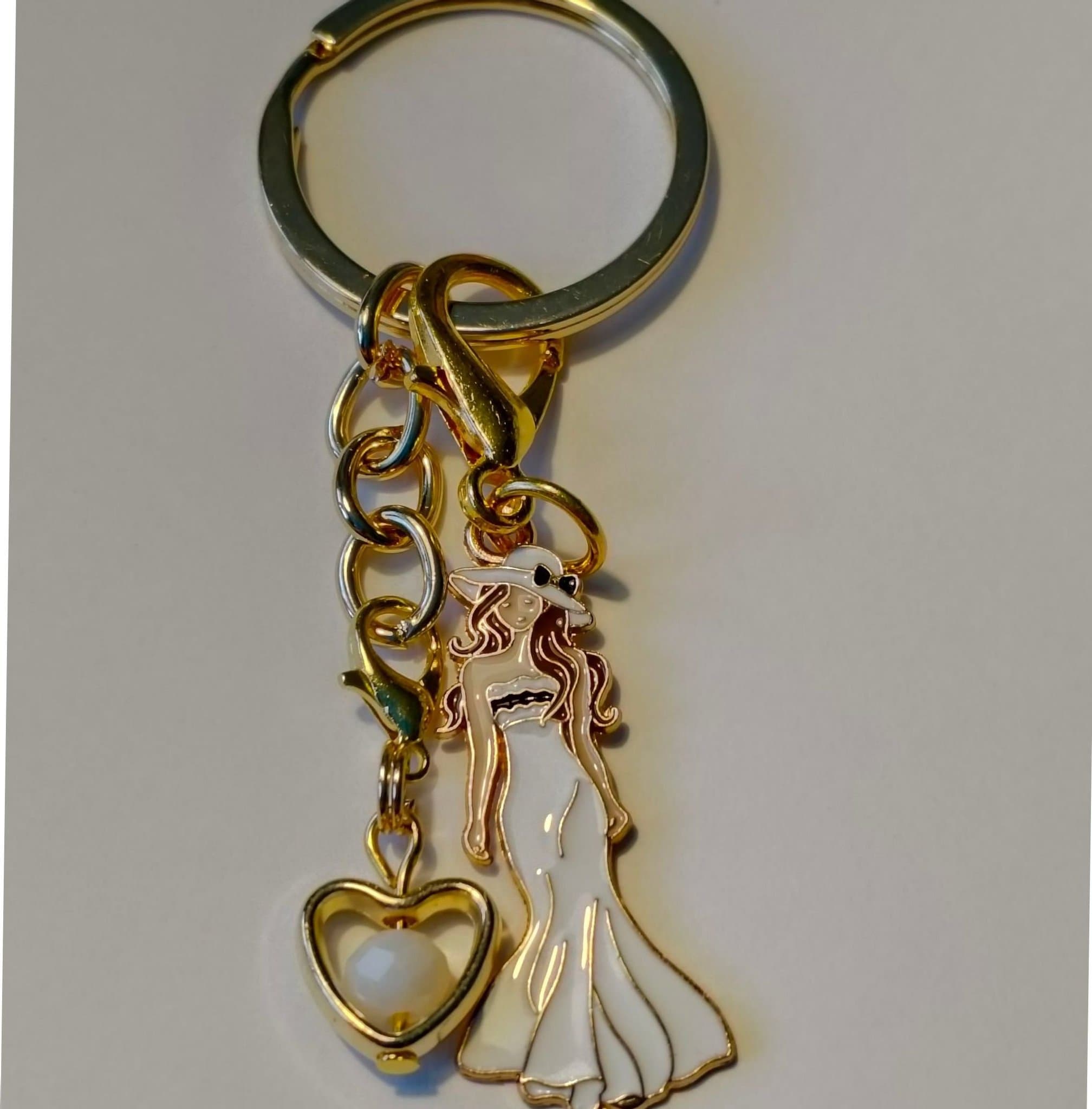 Fin Nyckelring med kvinna i Vit klänning och guld hjärta med Vit pärla inuti