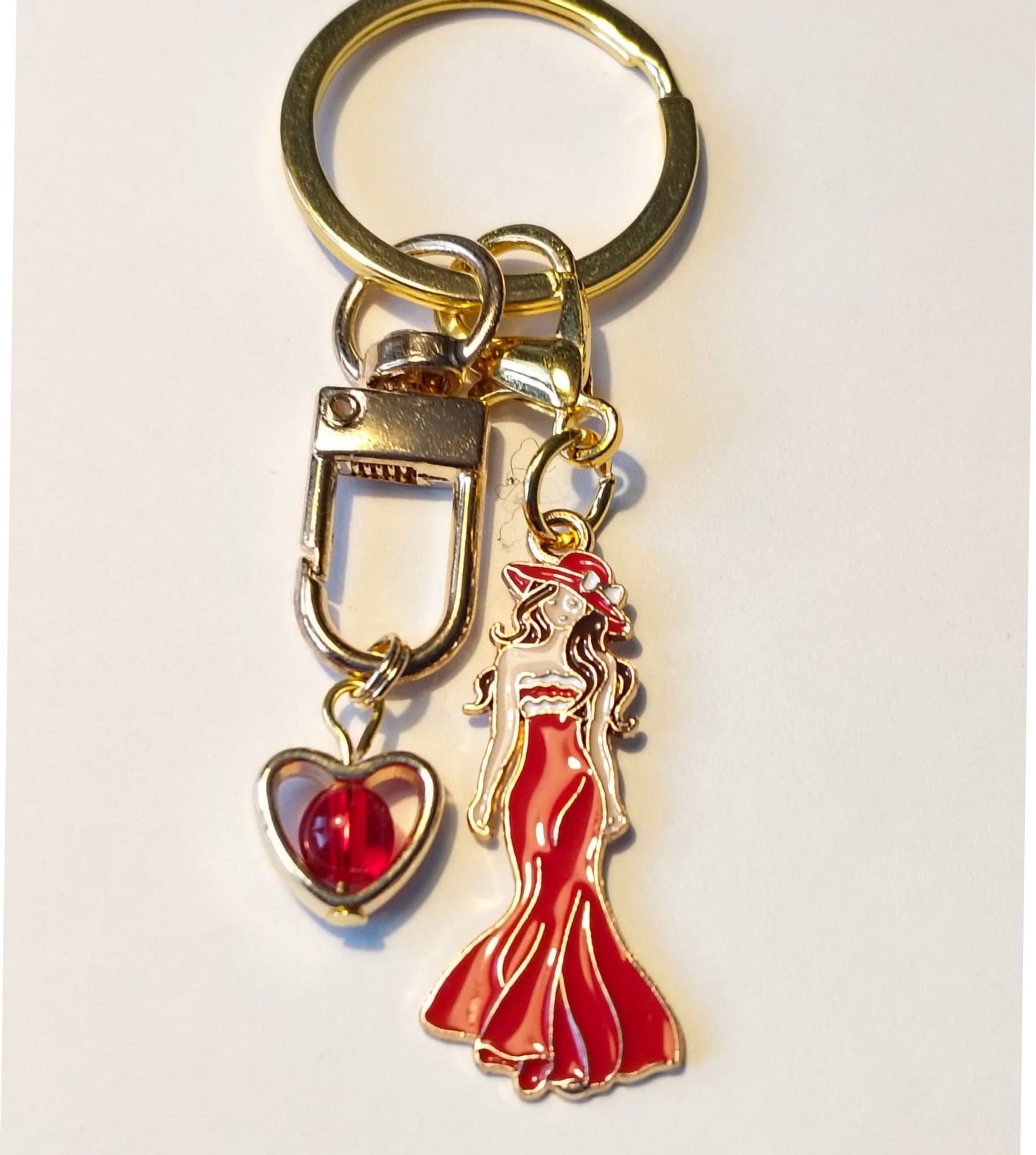 Fin Nyckelring med kvinna i Röd klänning och guld hjärta med röd pärla inuti