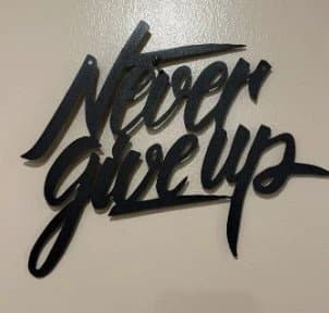 Svart metallskylt "Never Give Up" – 30x27 cm