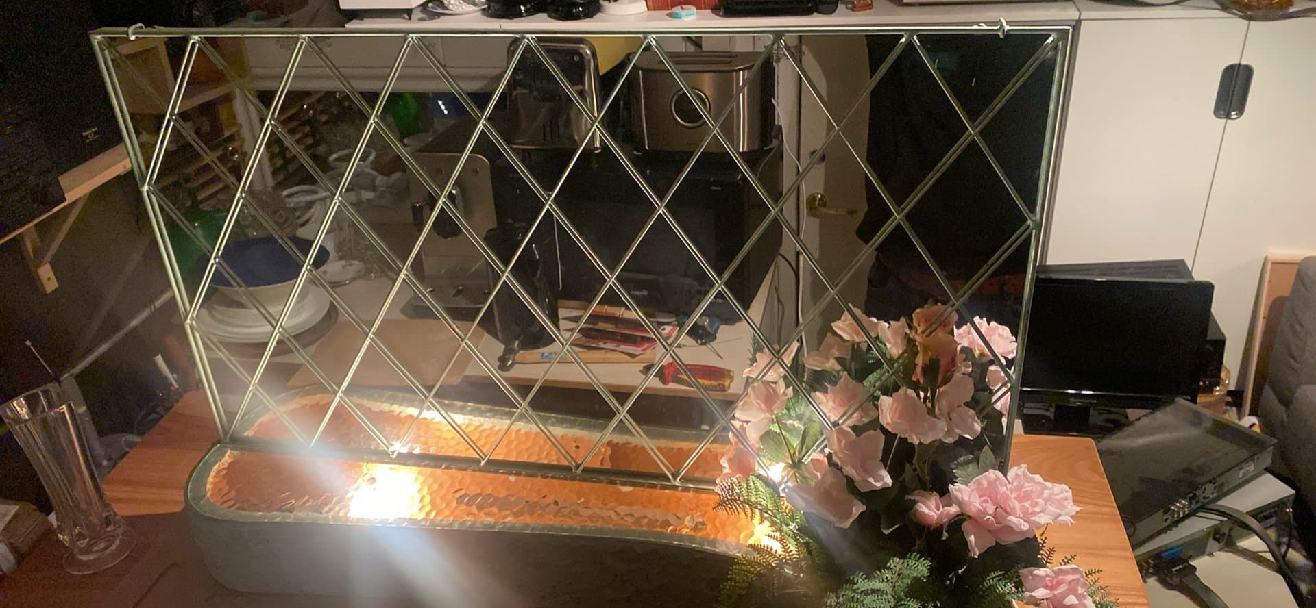 Väggspegel med belysning och blomsterarrangemang