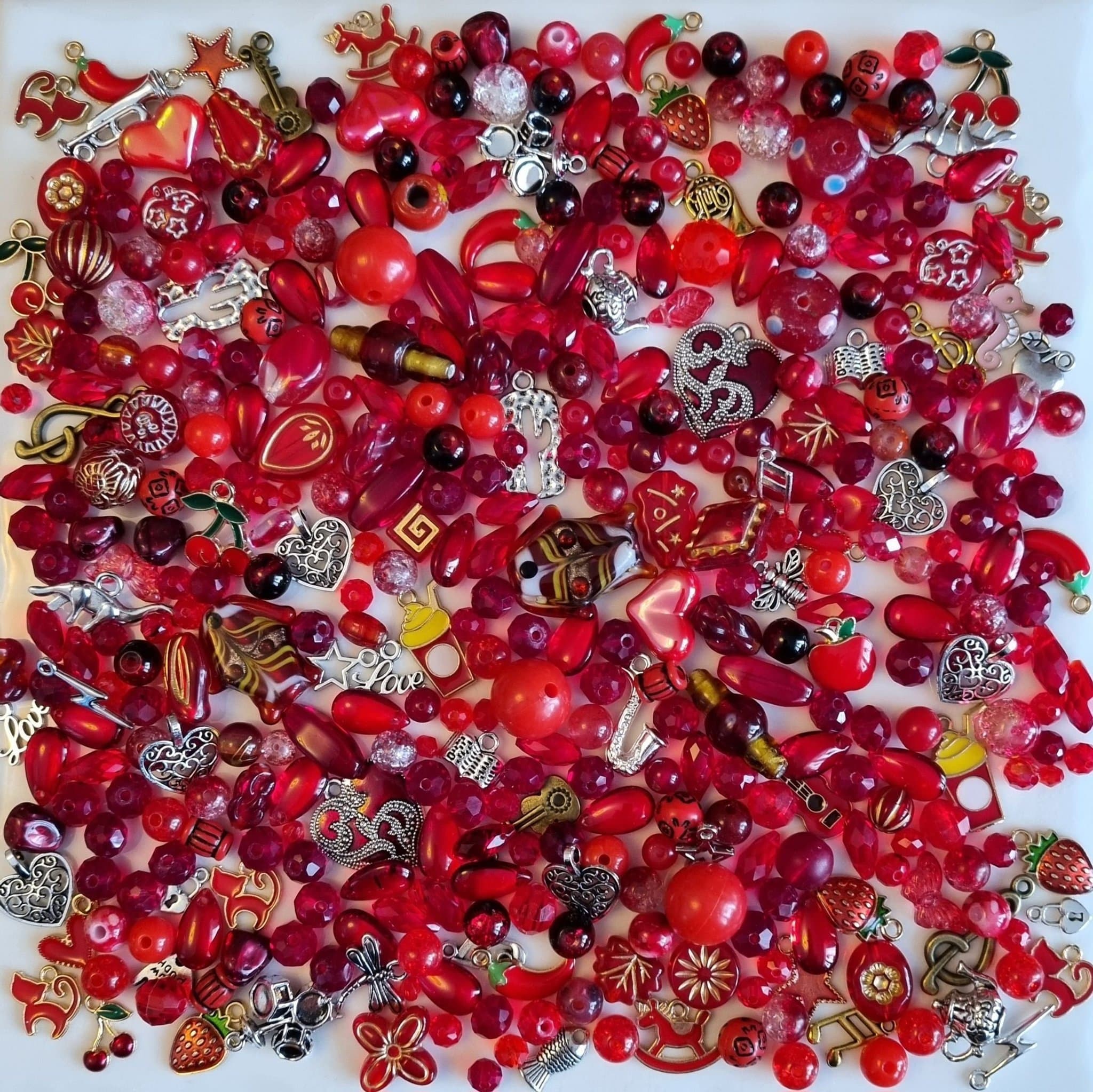 Blandad pärlor och berlocker i röda färger