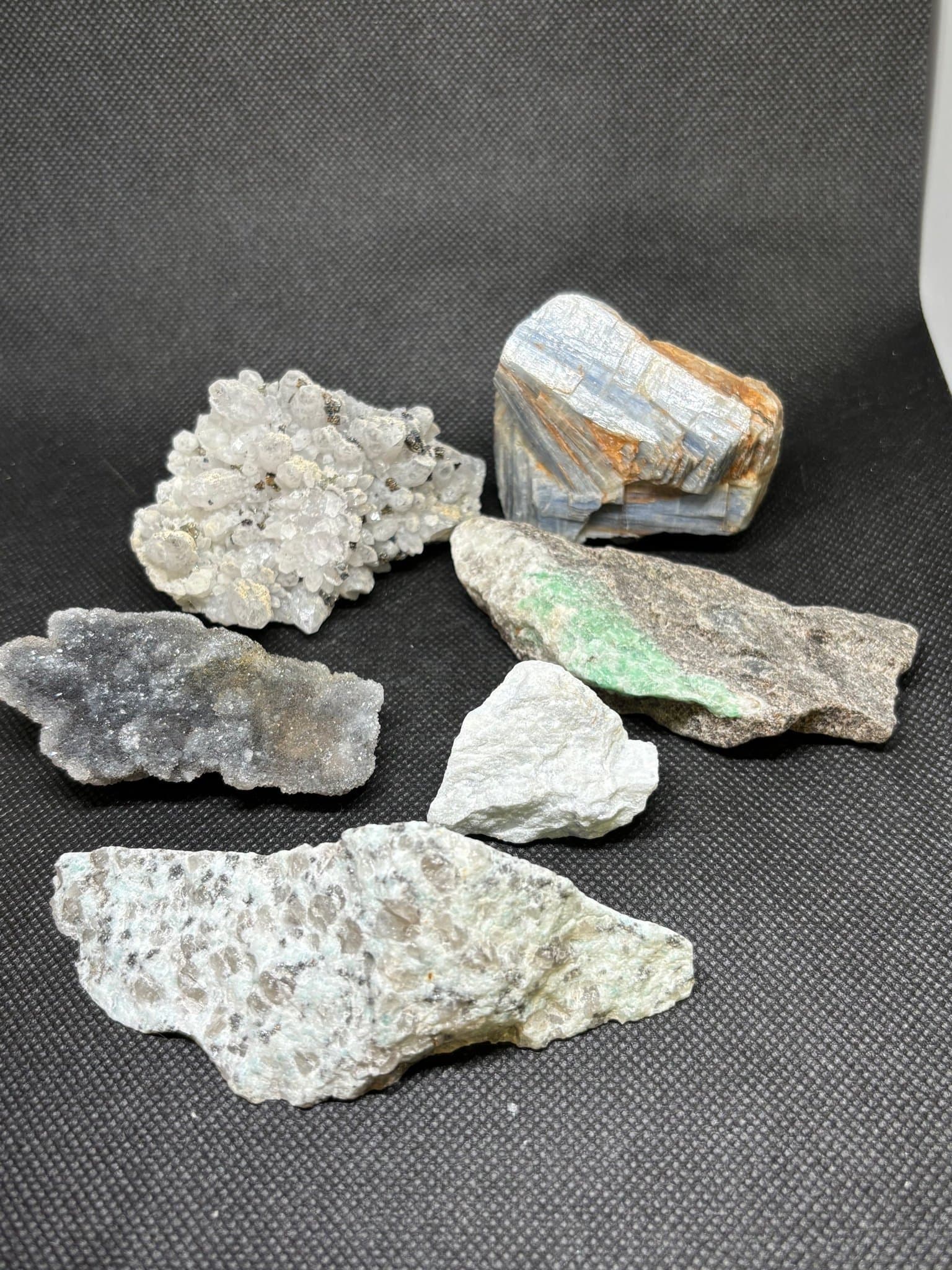 Parti råa kristaller smaragd, kalcit, mfl