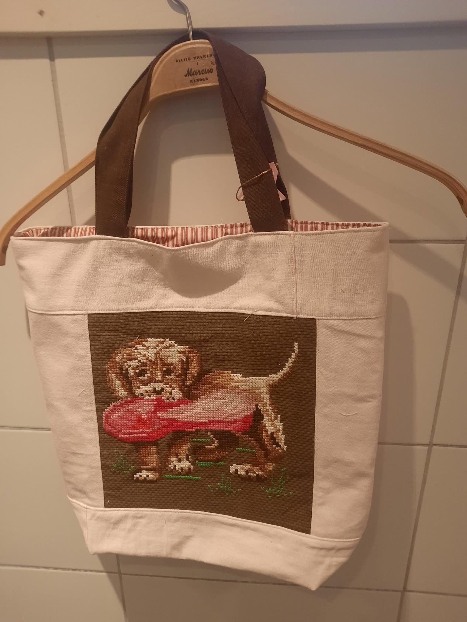 Kasse sydd av ljusrosa jeans, broderi och lakan, nysydd