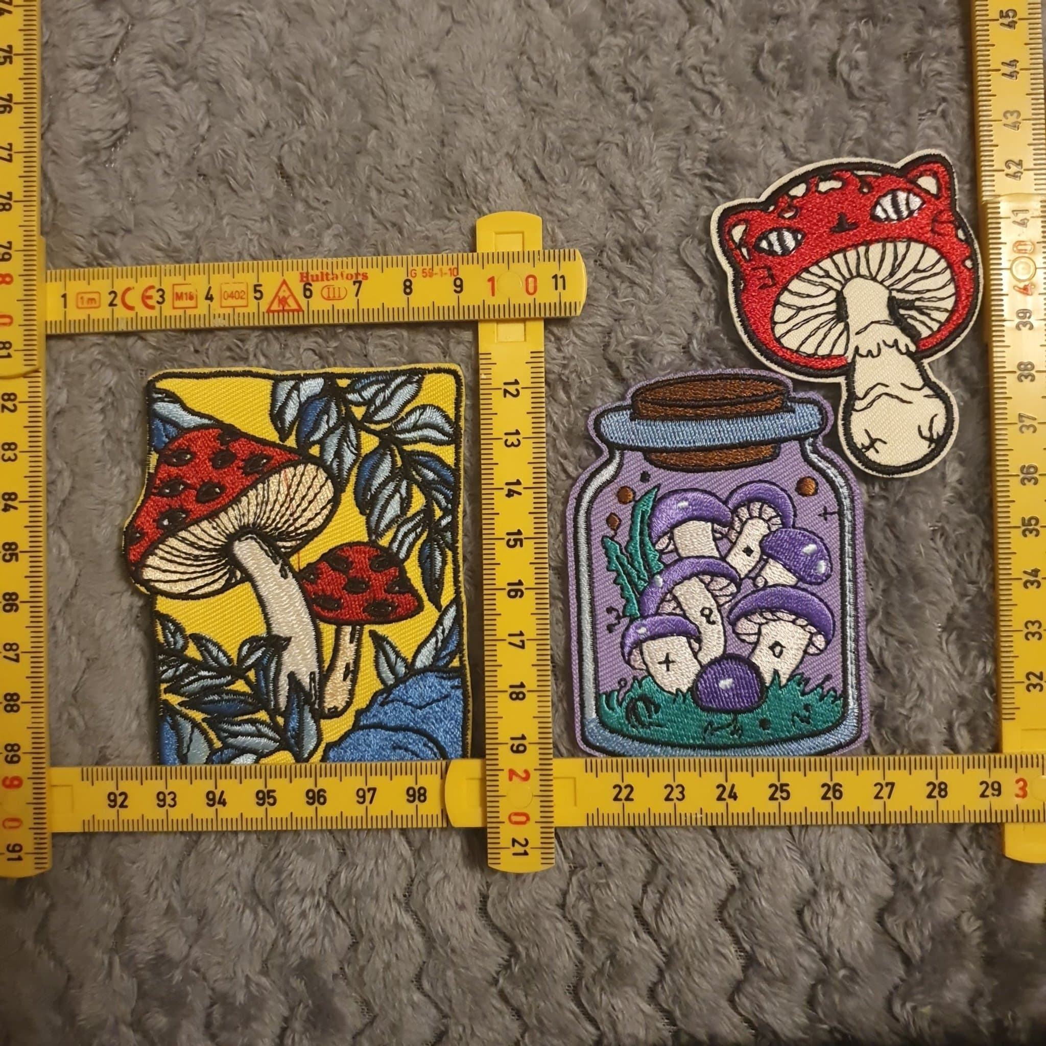 Tre broderade tygmärken med svampmotiv