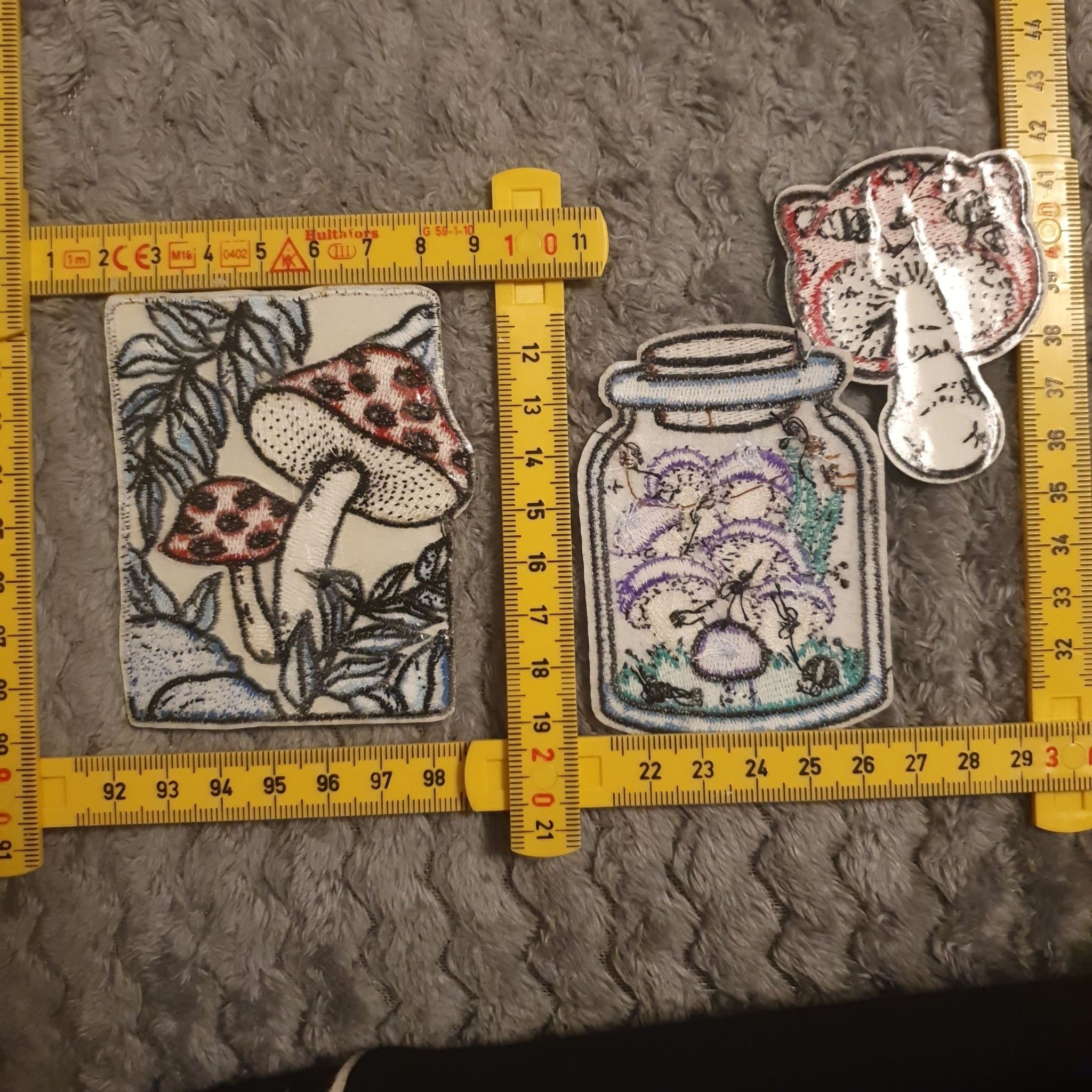 Tre broderade tygmärken med svampmotiv