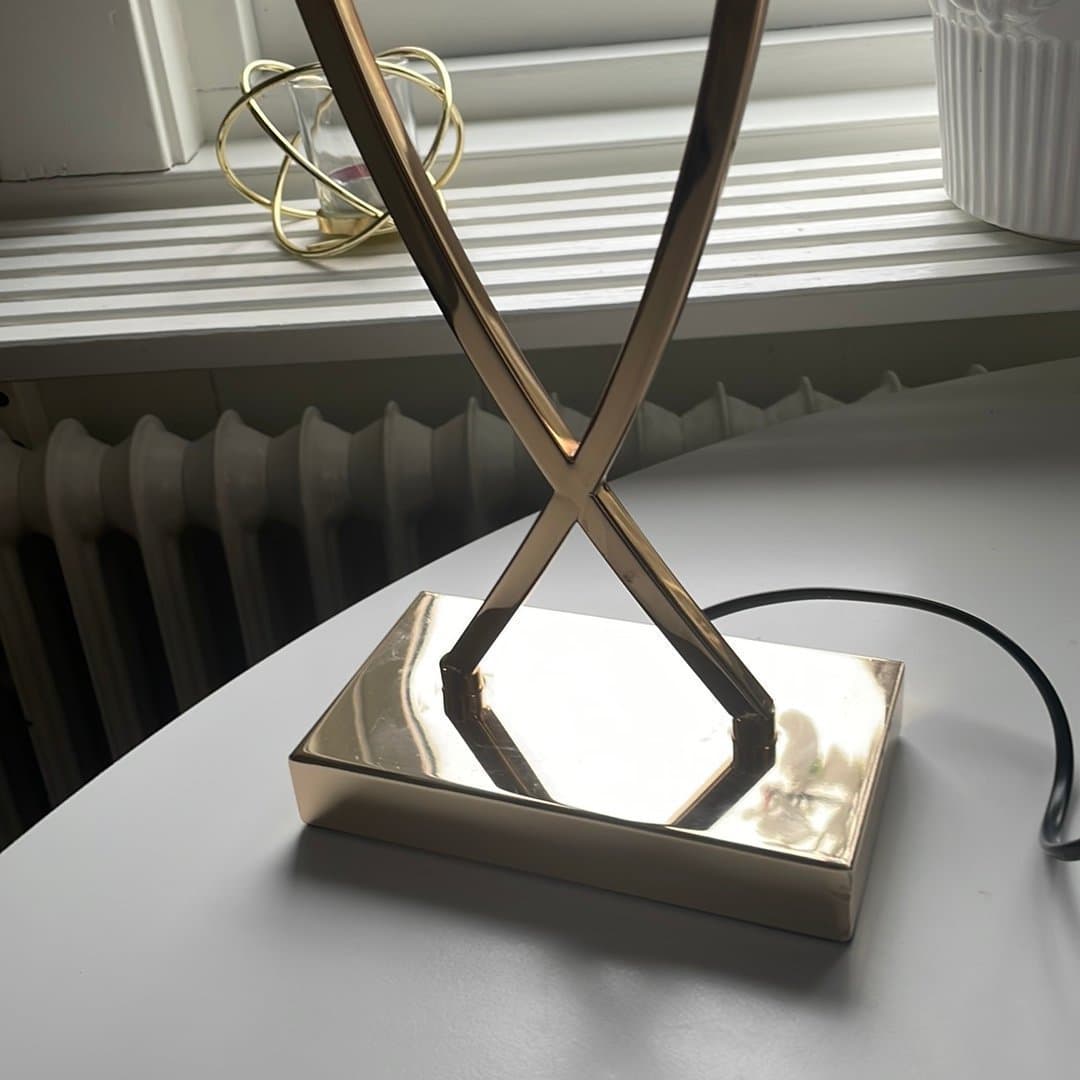 Bordslampa med guldfärgad fot och grå lampskärm