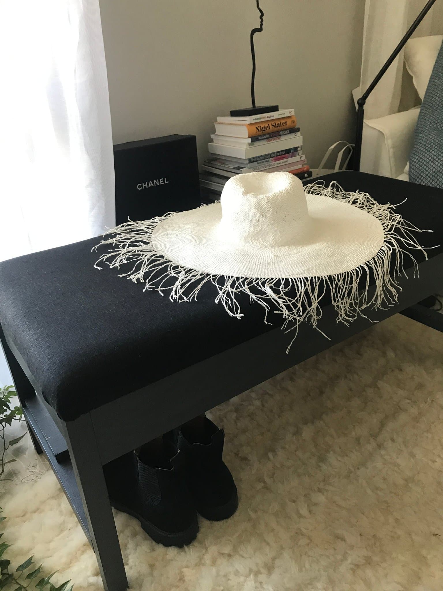 Stor svart förvaringsbänk i massivt trä, klädd i svart linne