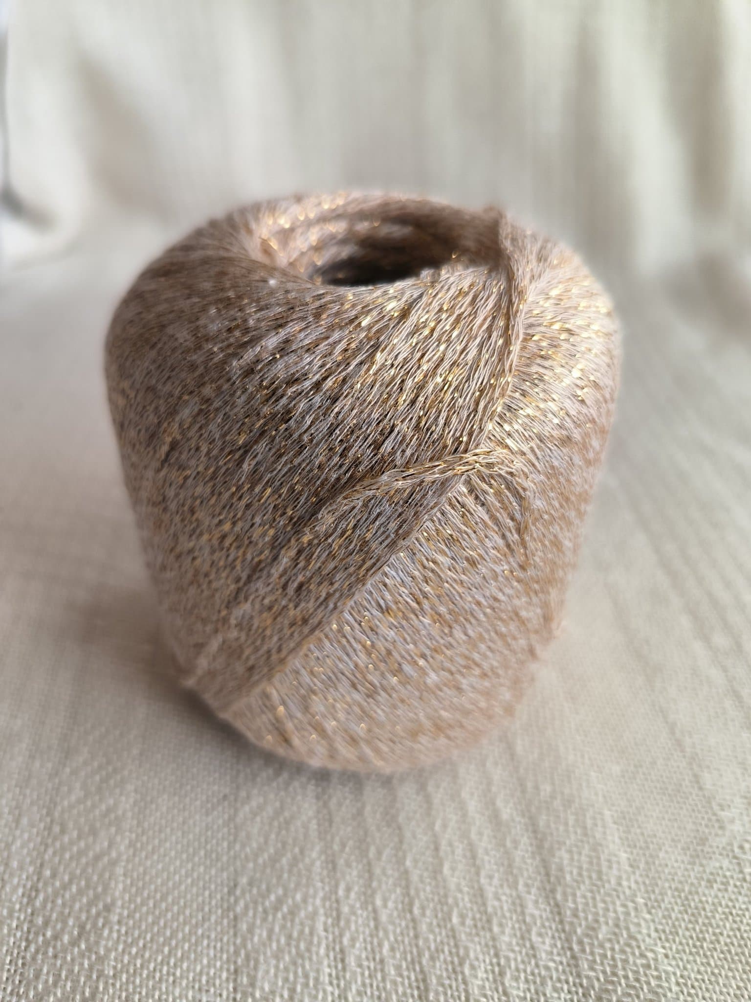 Glittrande garn 4x50gr med 70 % bamboo, 30% syntetfiber/rayon, beige/guld.