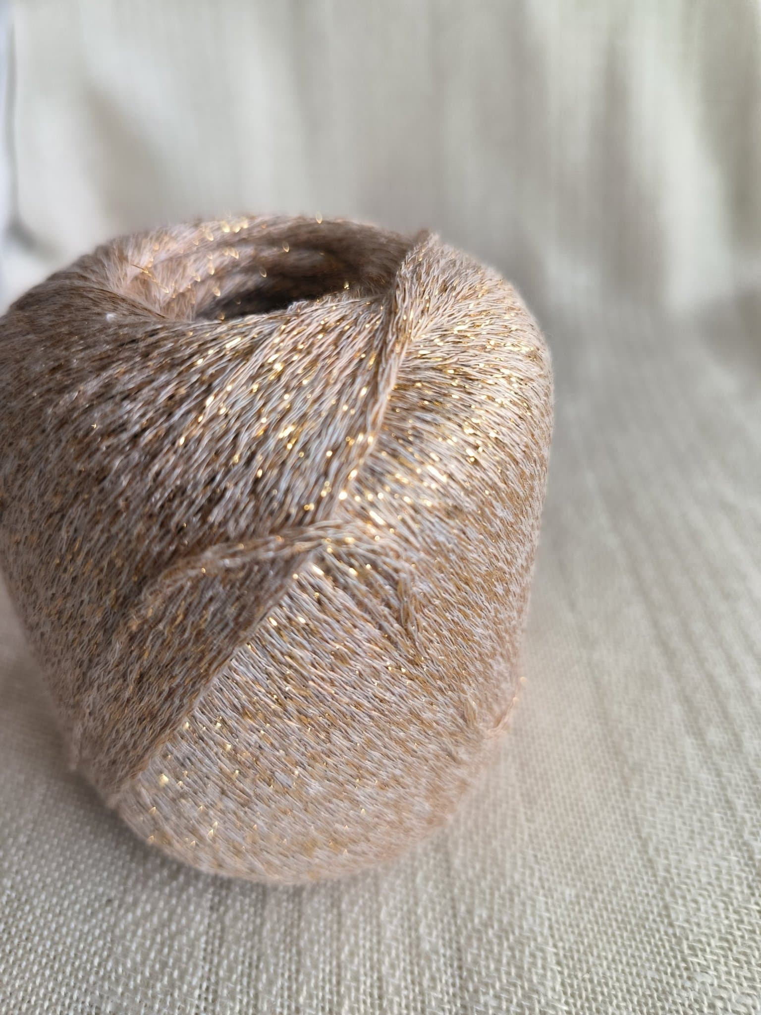 Glittrande garn 4x50gr med 70 % bamboo, 30% syntetfiber/rayon, beige/guld.