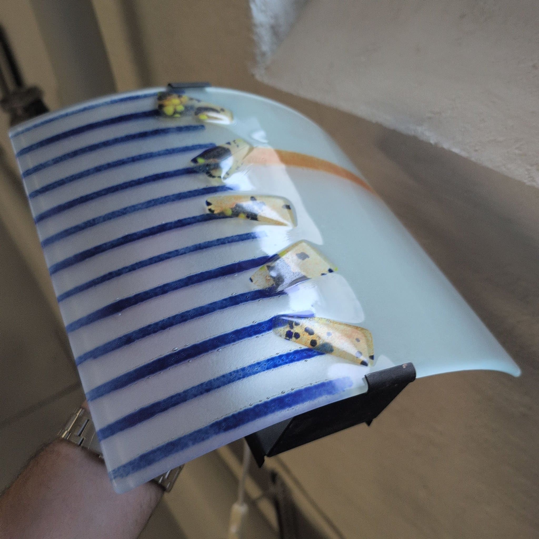 Modern vägglampa i frostat glas med blå och orange detaljer