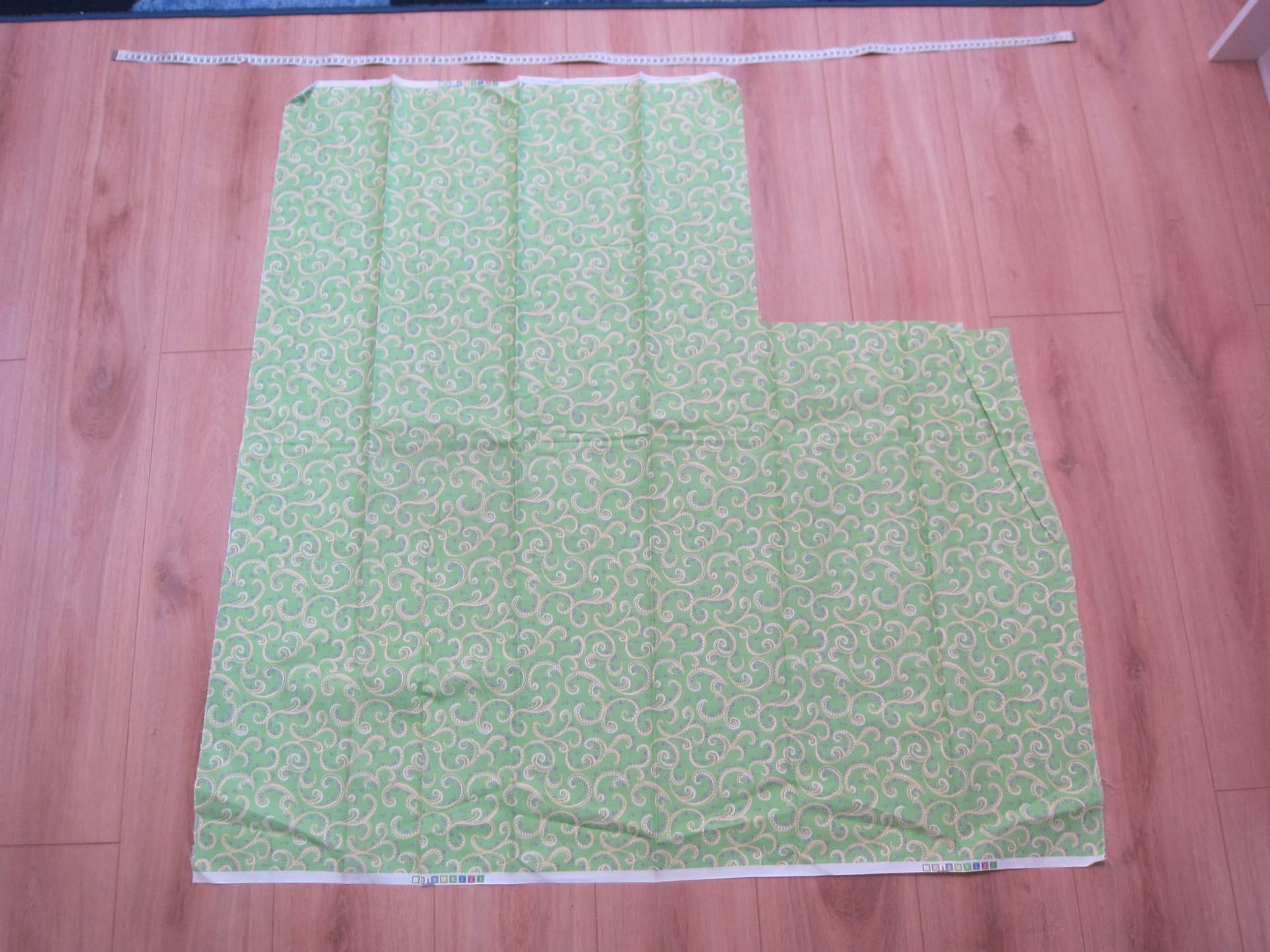 Mönstrat tyg i grönt/gult/lila/rosa ca 111x 110cm minus 40x41 cm