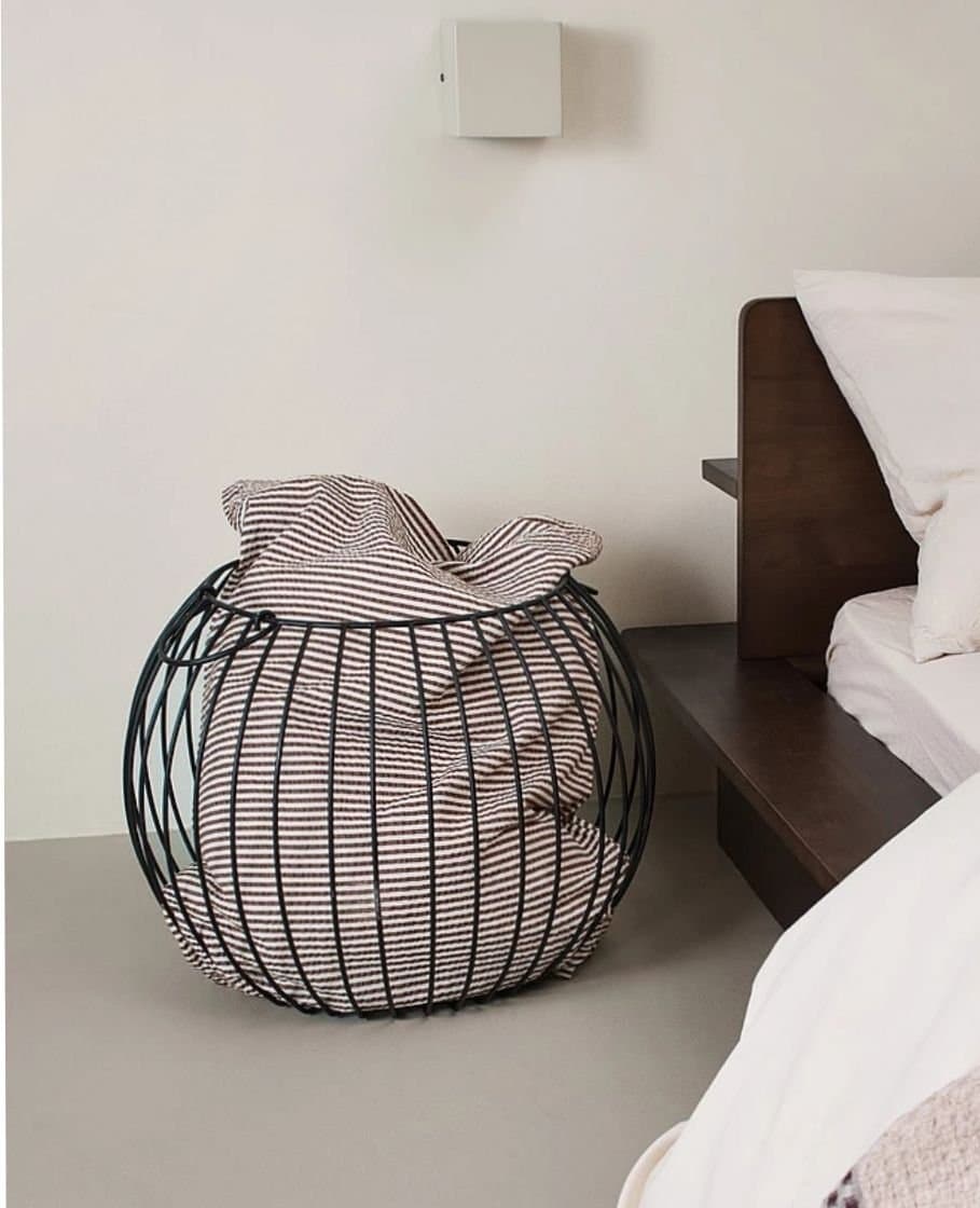 Svart rund korg i metall med två handtag