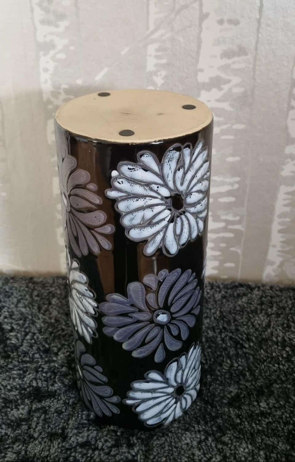 Svart vas med vita och grå blommor