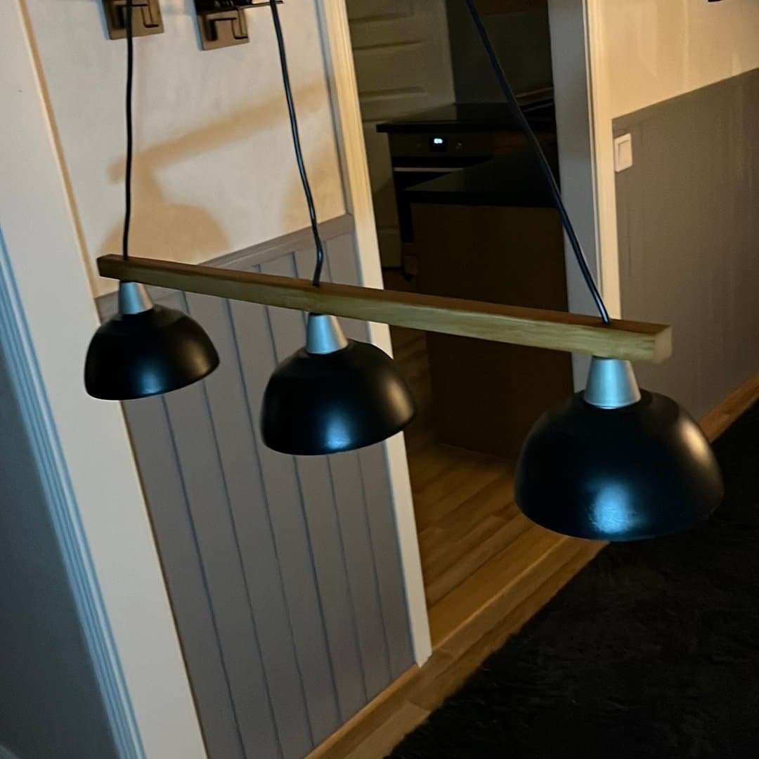 Taklampa med tre svarta skärmar och trädetalj