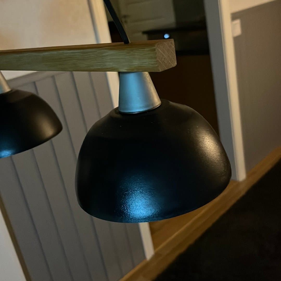 Taklampa med tre svarta skärmar och trädetalj