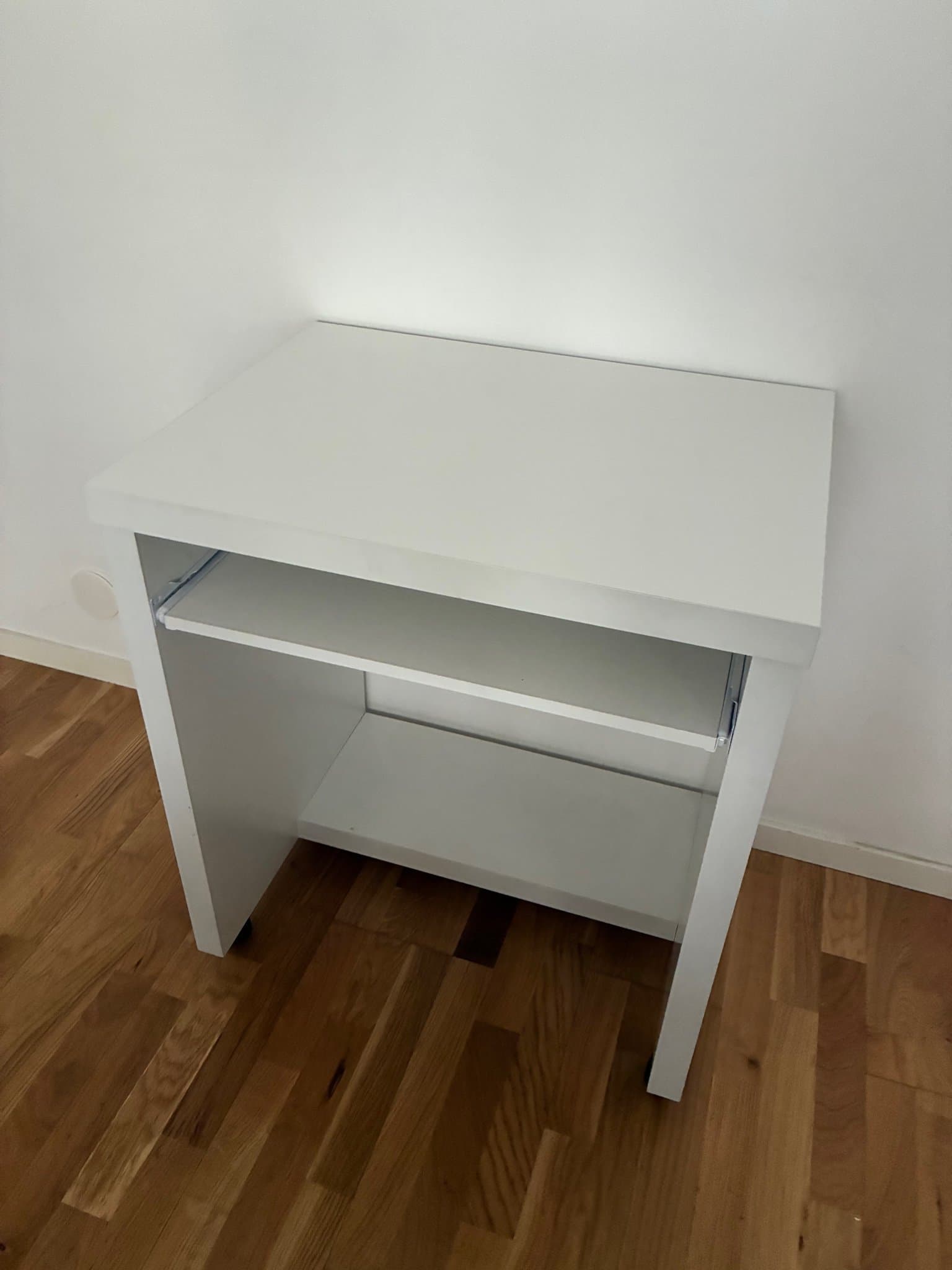 Vitt sängbord med utdragbar hylla och hjul