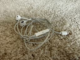 Apple originalhörlurar med lightningkontakt.
