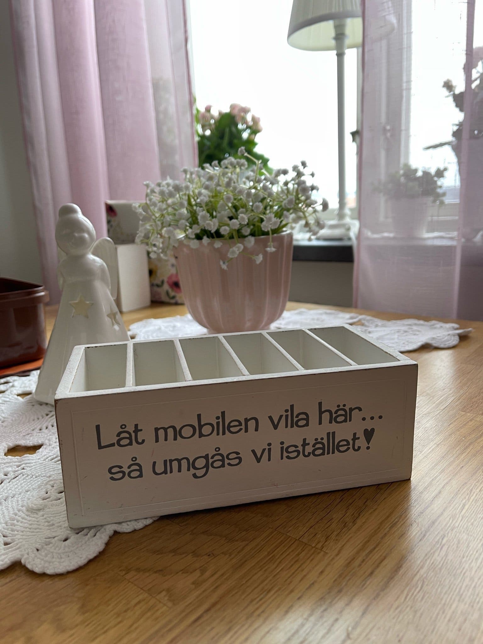 Mobilhållare i trä med texten "Låt mobilen vila här... så umgås vi istället!".