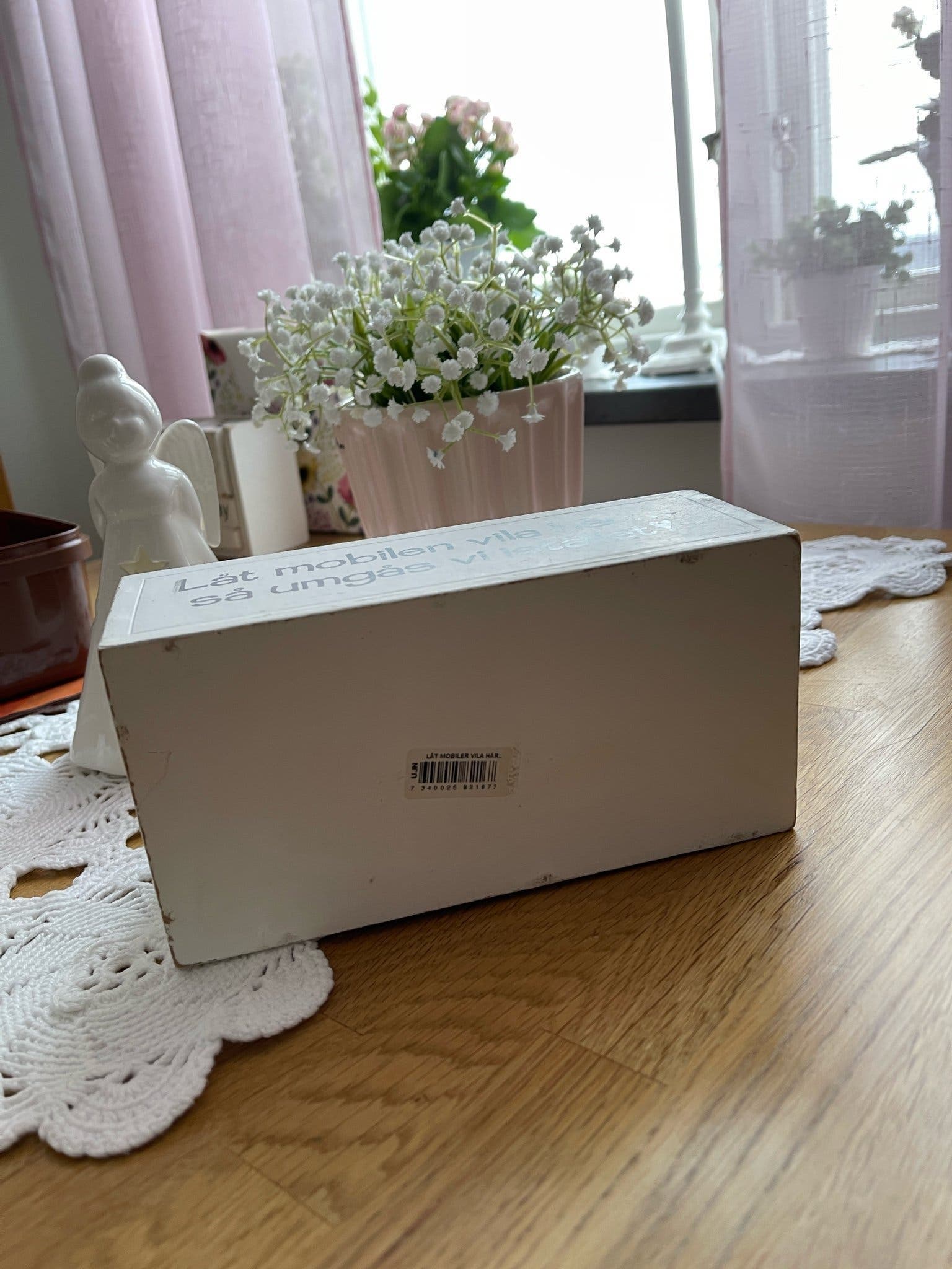 Mobilhållare i trä med texten "Låt mobilen vila här... så umgås vi istället!".