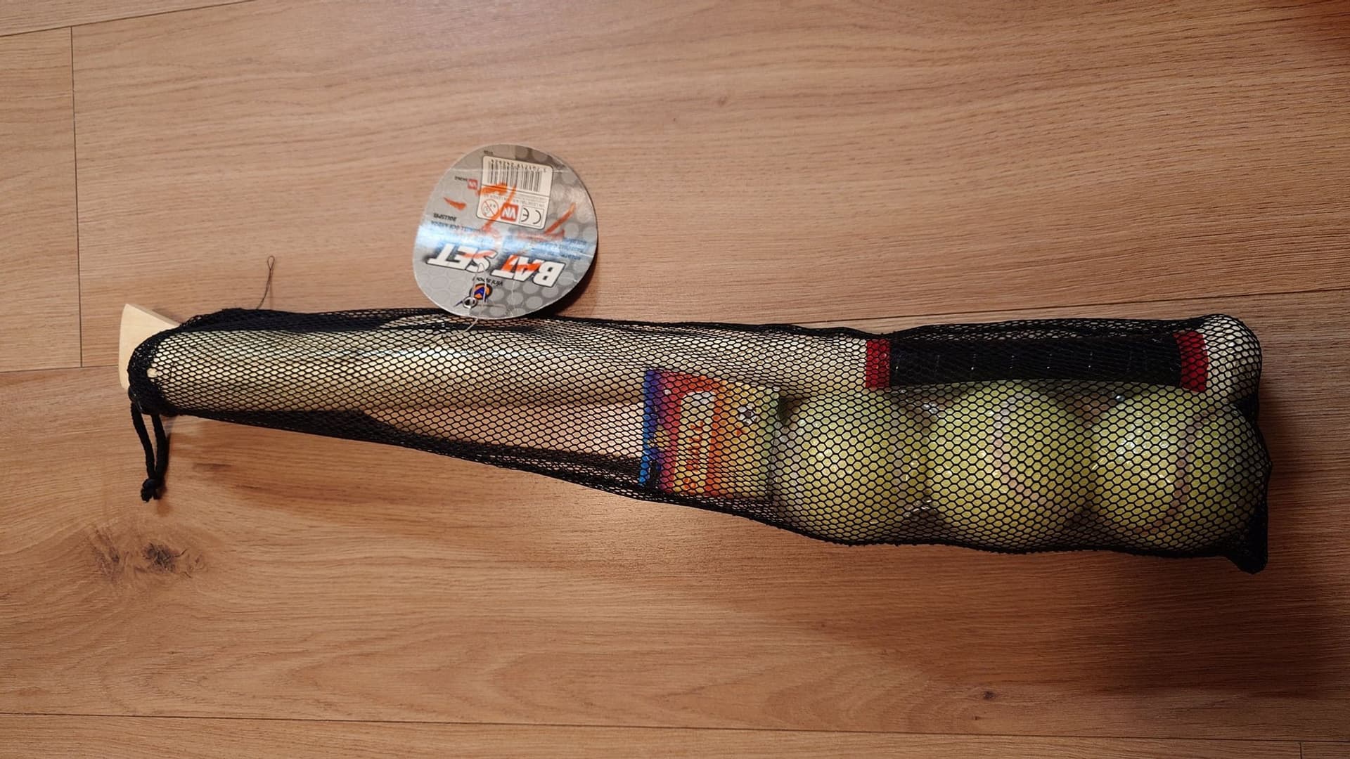 Basebollträ med bollar i nätpåse