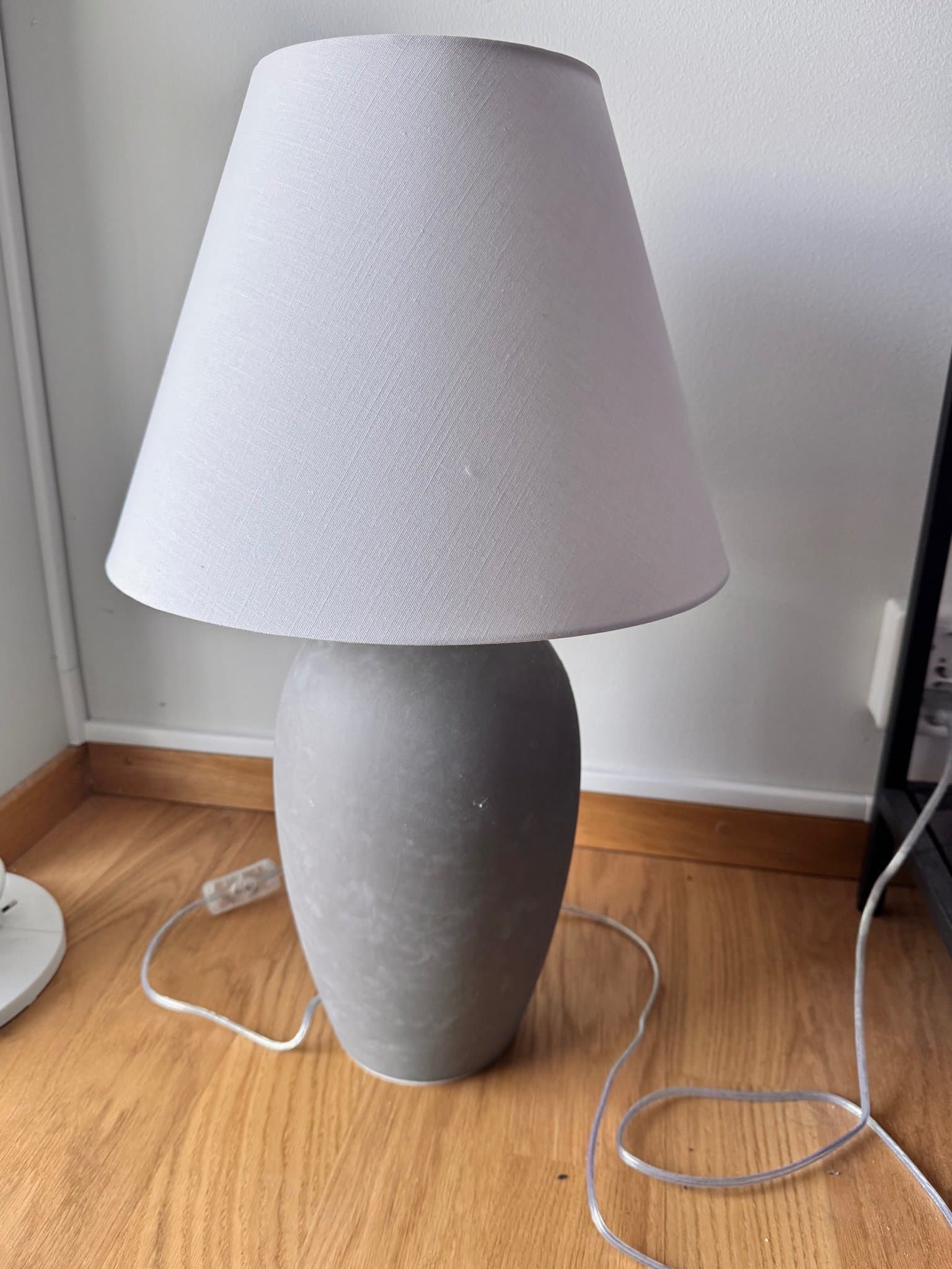 Stor lampa med grå fot och vit skärm