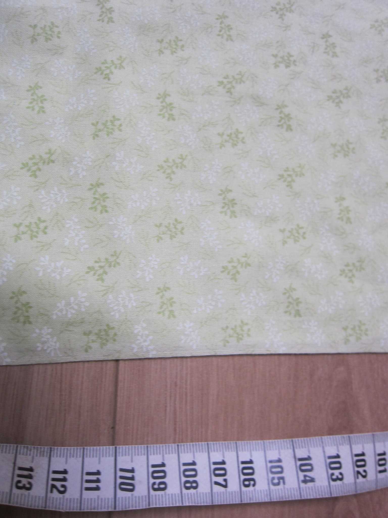 Mönstrat ljusgrönt tyg ca 300x 114cm minus ca 41x41 cm